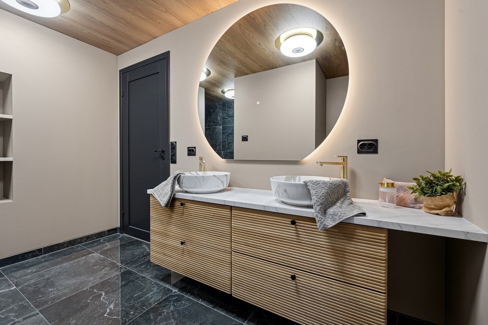 Innredningen er praktisk med to overliggende servanter, et veggmontert toalett og to separate dusjnisjer. Galleribilde