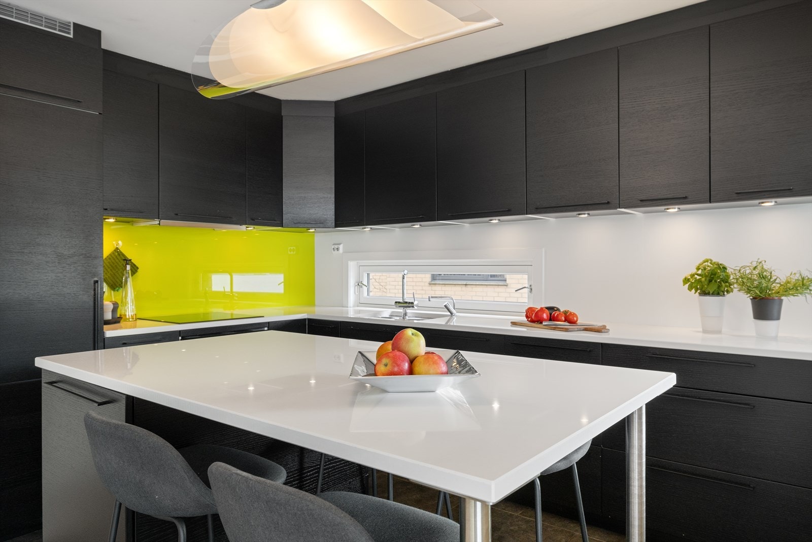 Det er rikelig med arbeidsplass på den lyse benkeplaten av stein med nedfelt vask. Galleribilde