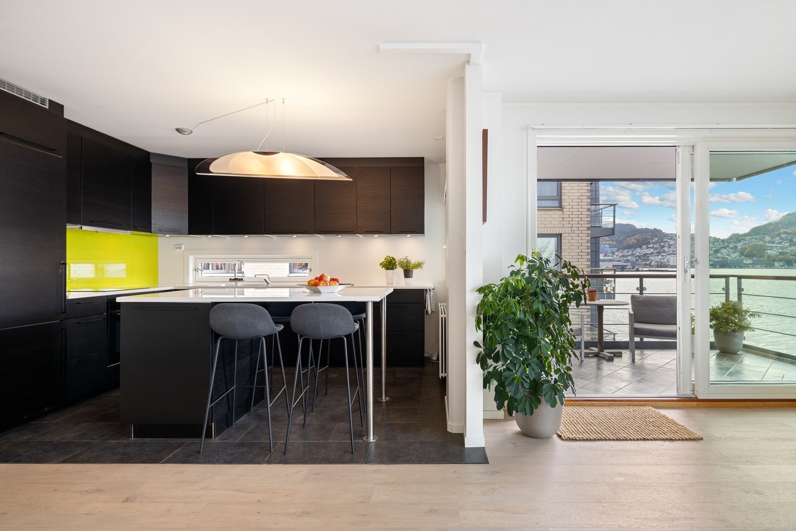 Velutrustet kjøkken med mørke glatte fronter. Galleribilde