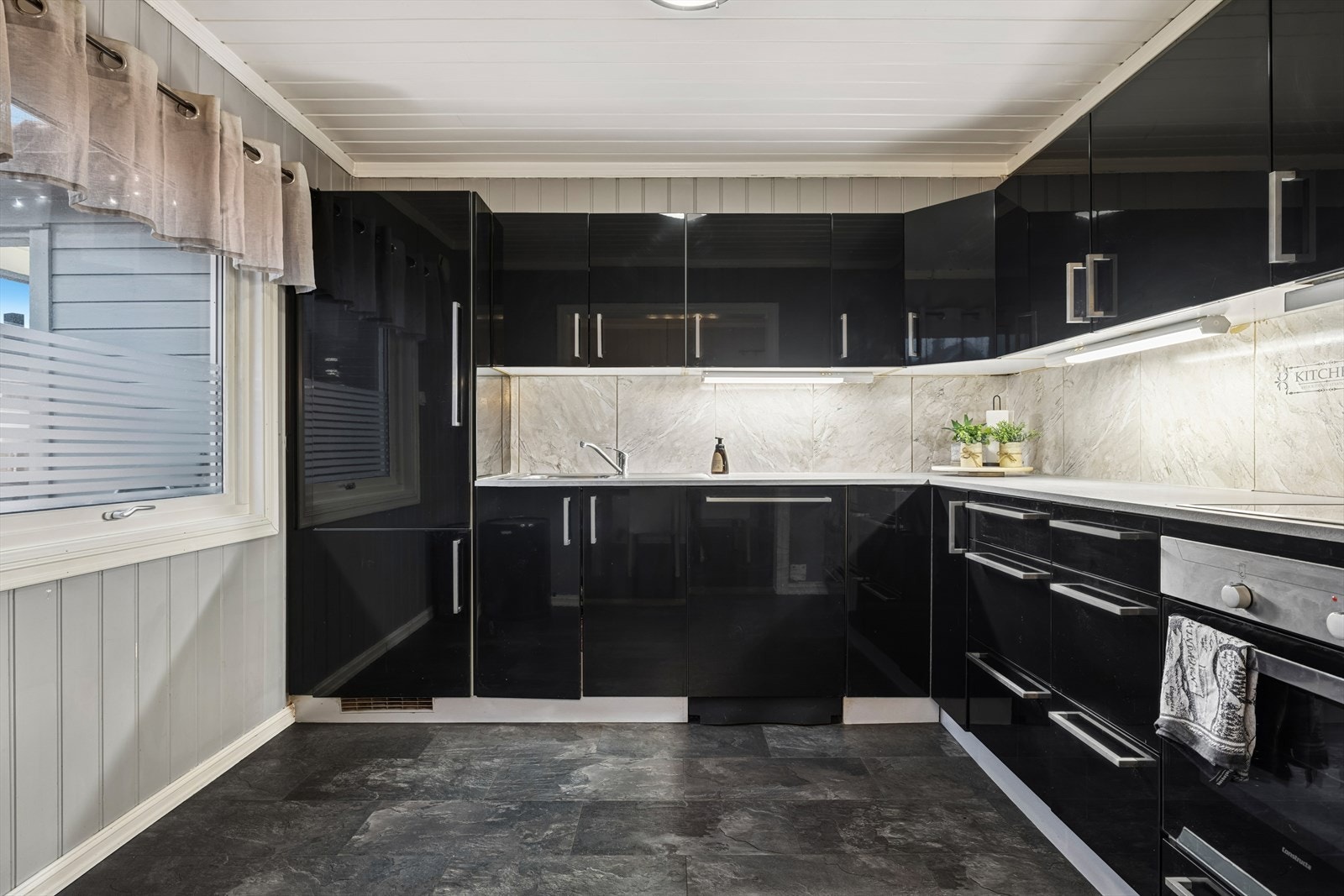 Kjøkkenet har integrert komfyr, koketopp, oppvaskmaskin og kombiskap. Galleribilde