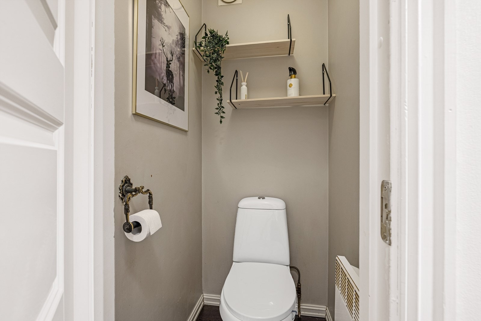 Toalettrom med gulvmontert toalett. Laminatgulv. Malt på vegger Galleribilde