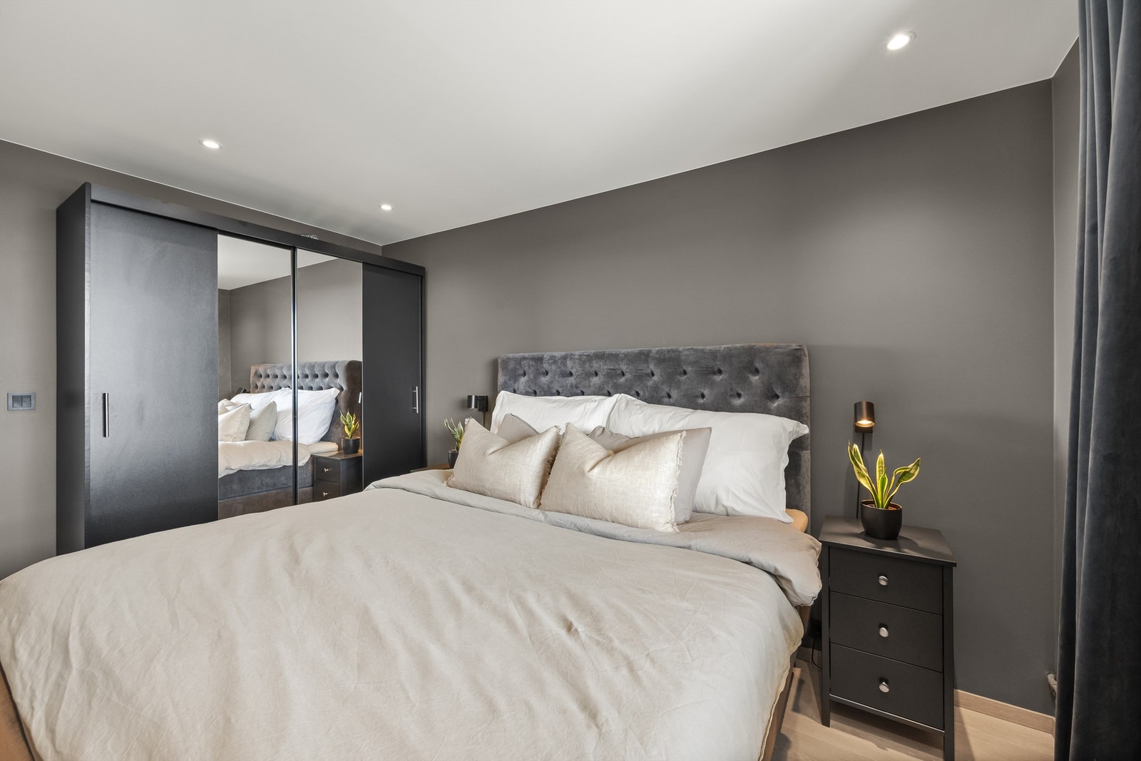 Soverom med skyvedørsgarderobe i mørk og glatt utførelse samt speilfronter Galleribilde