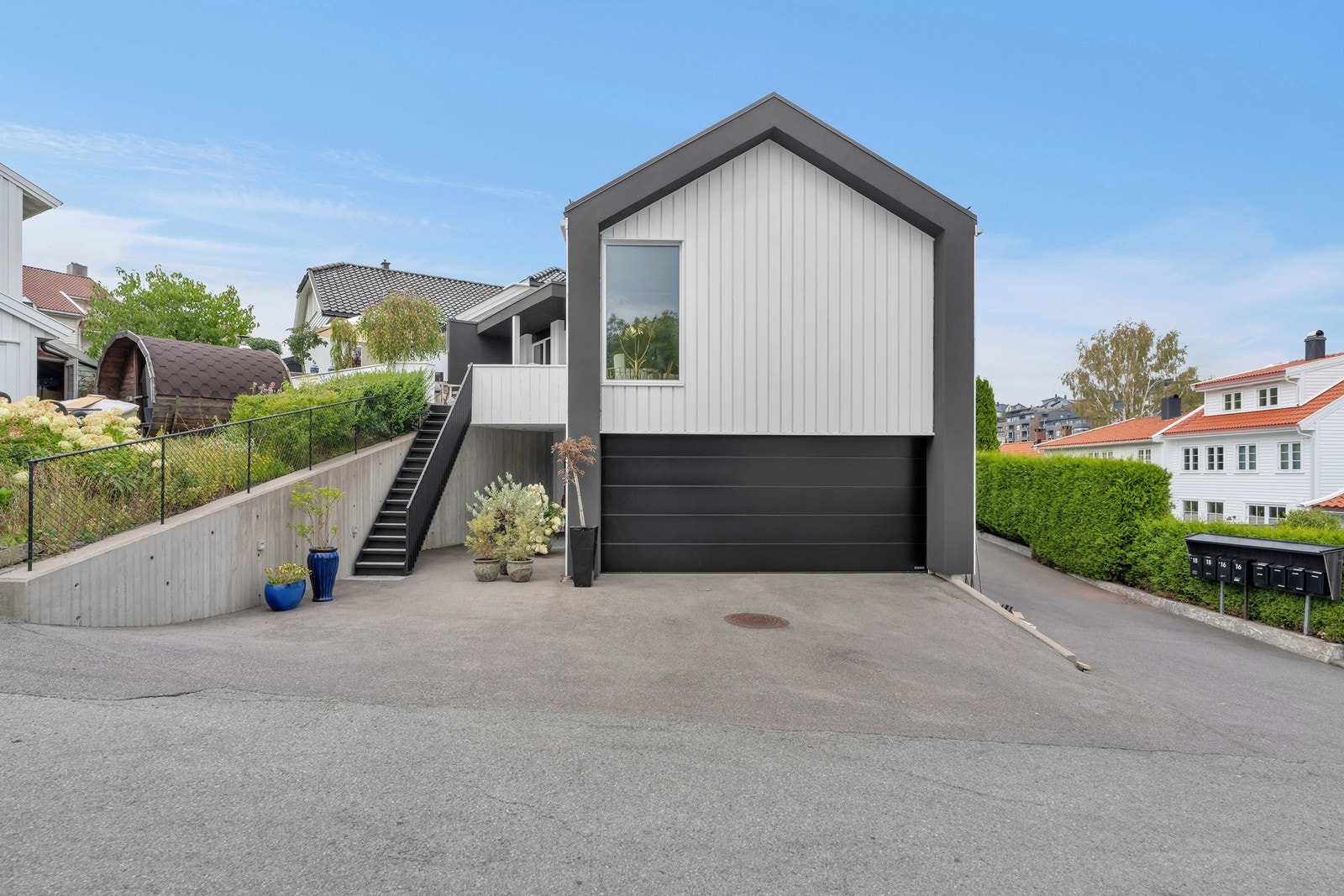 Innkjørselen til eneboligen. Det er nå montert gjerde på muren til høyre også (samme gjerde som på muren til venstre). Gjerder levert av anerkjente Søndergaards Sveiseverksted AS Galleribilde