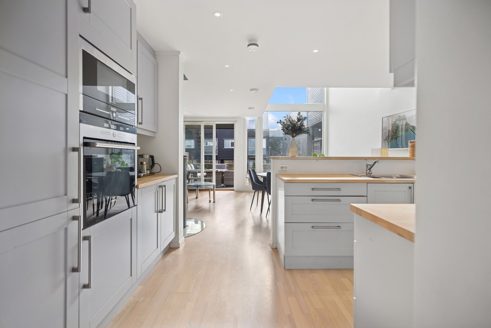 Kjøkkenet ligger i en delvis åpen og sosial løsning mot stuen og spisesonen, noe som skaper en naturlig flyt mellom matlaging og måltider. Galleribilde