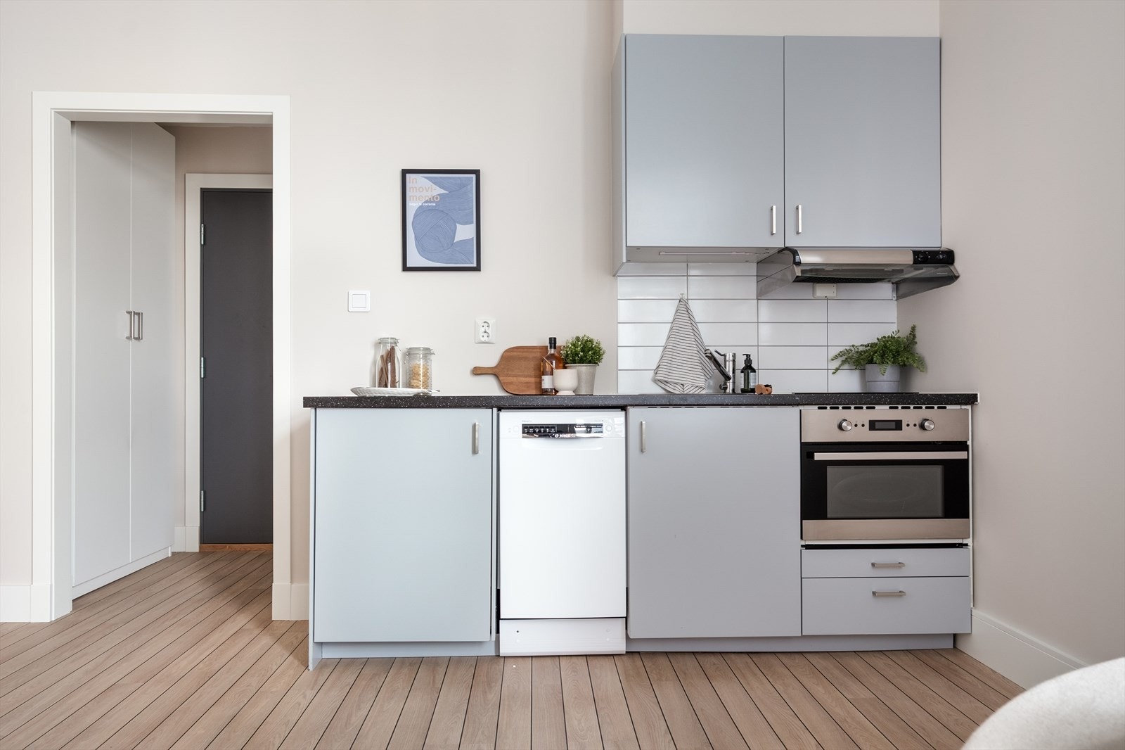 Tidsriktig glatt innredning fra IKEA, led lys under overskap, laminat benkeplate med nedfelt stålkum og keramisk topp, integrert komfyr, oppvaskmaskin (smal type), kjøleskap. Galleribilde