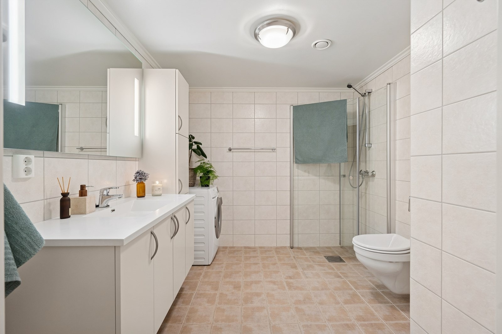 Delikat flislagt bad med elektriske varmekabler i gulvet. Dusjsonen er nedsenket med godt fall mot sluk, og det er dusjhjørne med glassvegger. Galleribilde