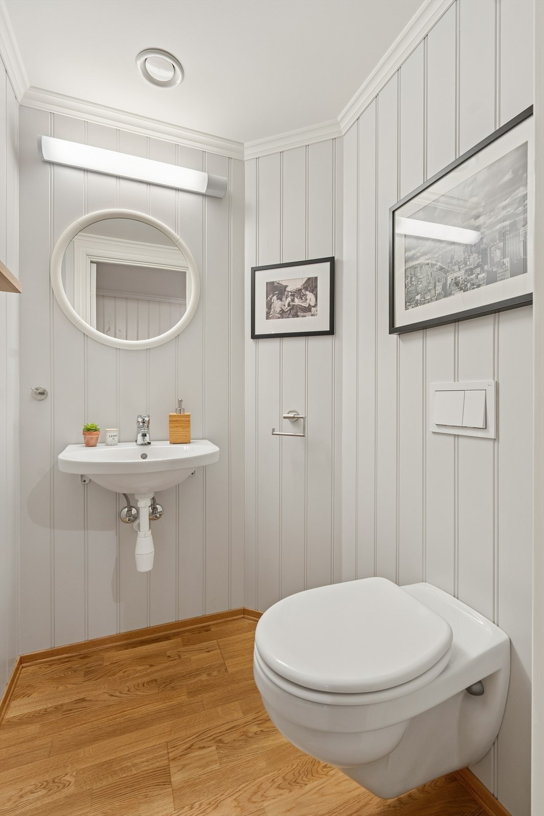 Eget toalettrom med parkett på gulv, varmekabler, servant og vegghengt speil. Galleribilde