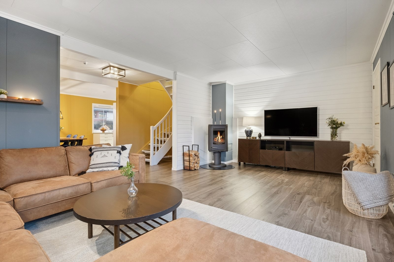 En romslig og god stue med peisovnen sentralt plassert på stuen. Galleribilde