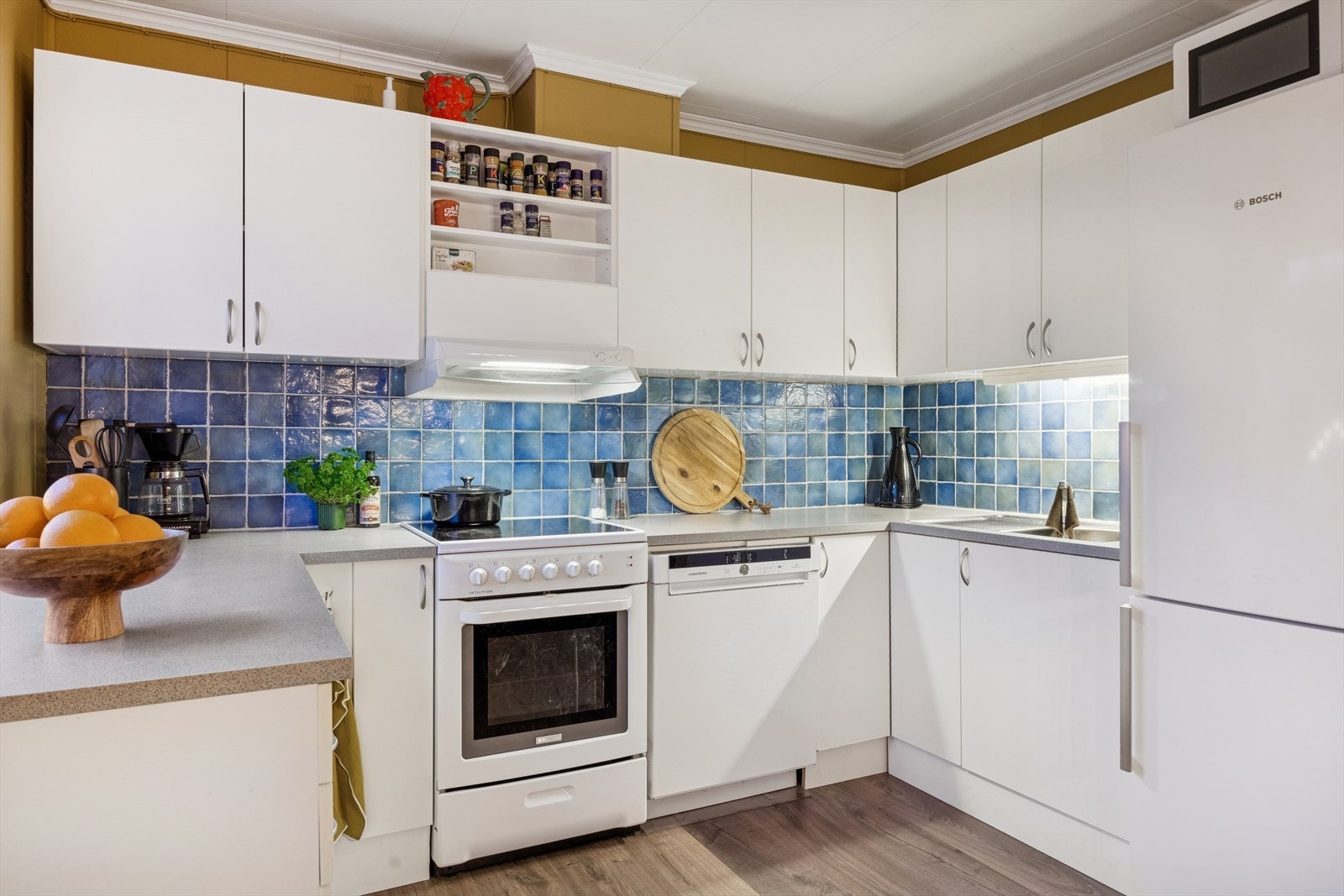 Lyst kjøkken med flis over benk. Galleribilde