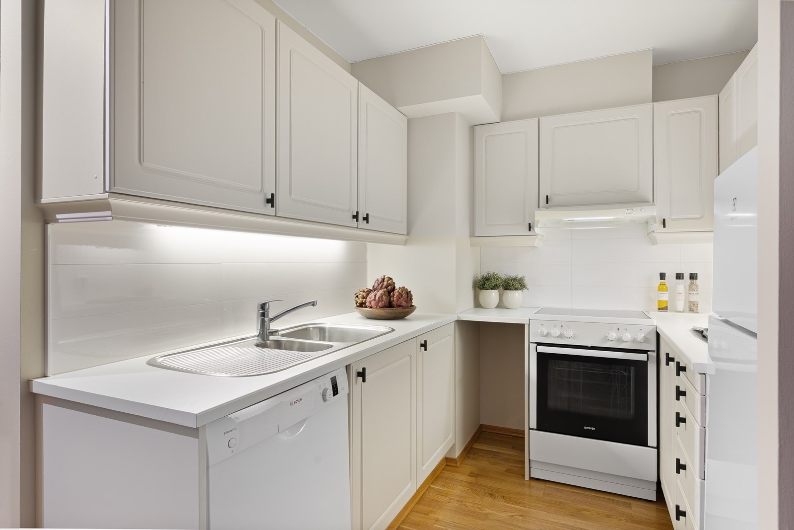 Kjøkkenet er utstyrt med laminert benkeplate med overliggende oppvaskkum og ettgreps blandebatteri fra Oras. Galleribilde