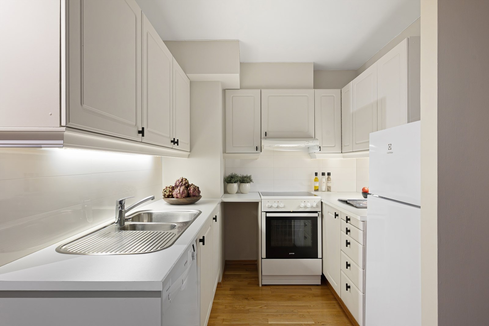 Pent og velholdt eldre kjøkken med profilerte fronter. Galleribilde