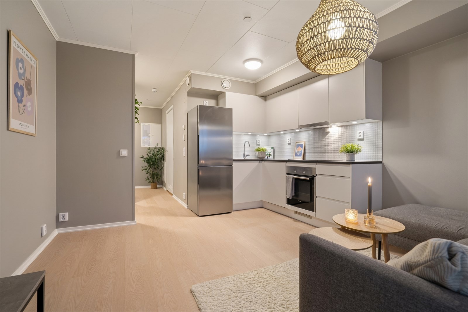 Kjøkkenet ligger i åpen løsning og har innredning med glatte fronter, laminert benkeplate og fliser på vegg over benk Galleribilde