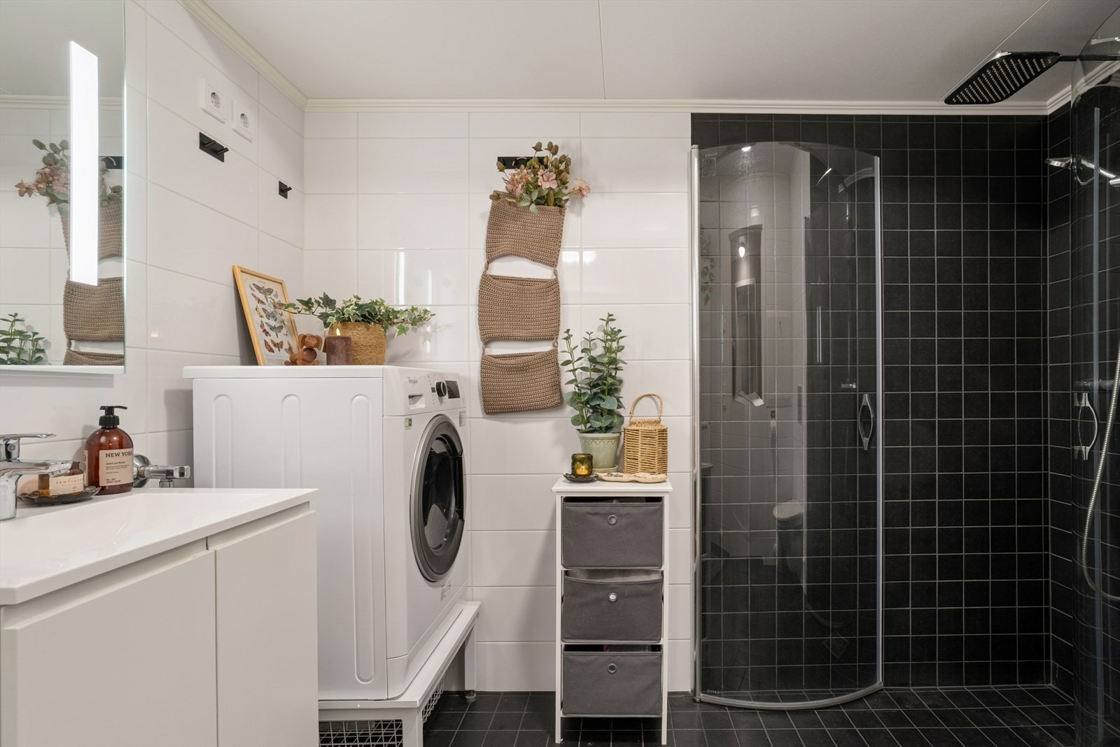 Badet er utført med mørke fliser på gulv og i dusjsonen, for øvrig er det hvite veggfliser - Gulvet er oppvarmet med elektriske varmekabler Galleribilde