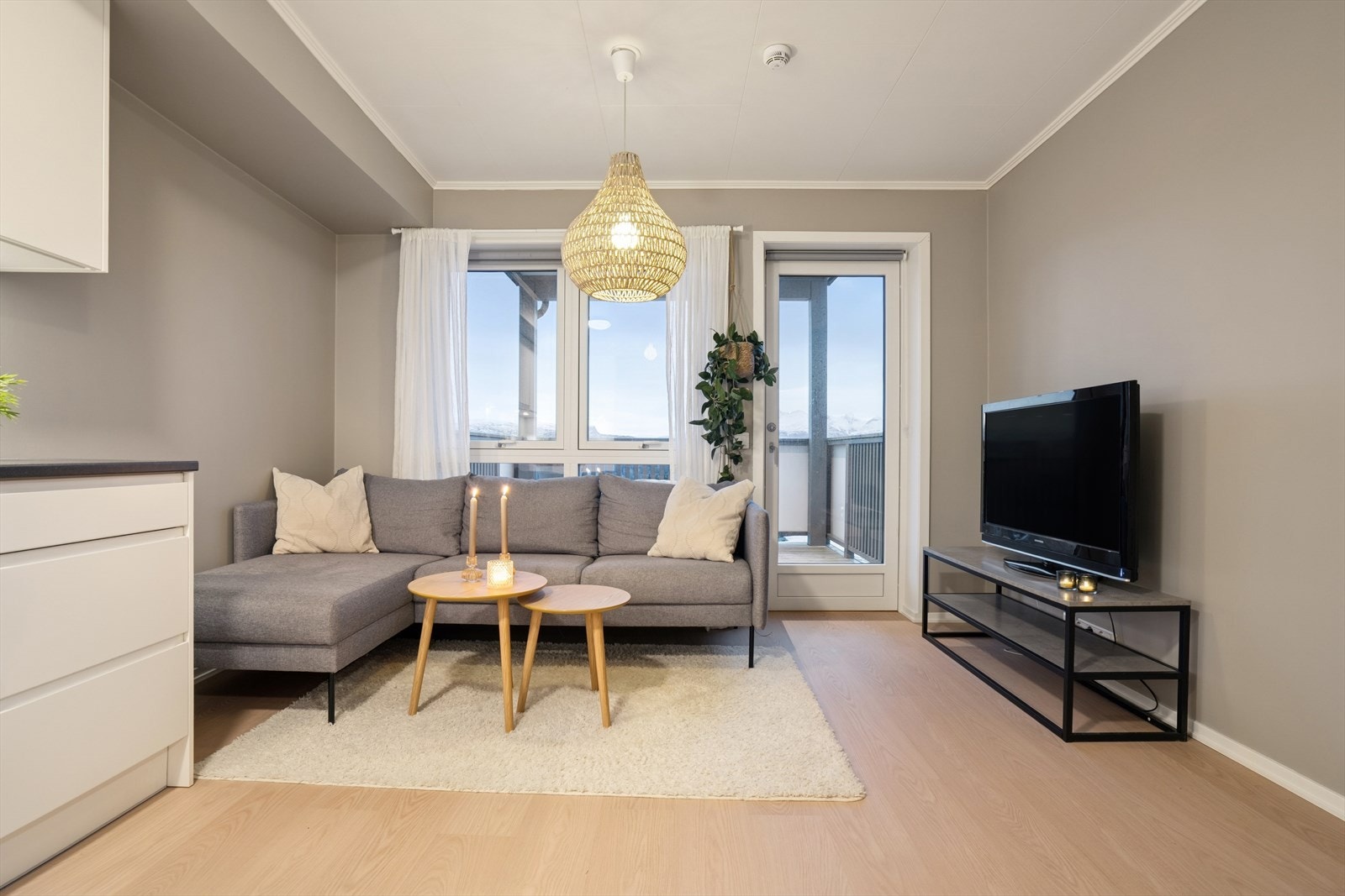 Stuen er malt i en moderne fargetone og har store sørvendte vindusflater som slipper inn rikelig med dagslys Galleribilde