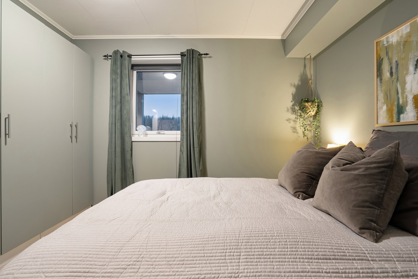 Garderobeskapene er malt i samme farge som veggene og gir deg rikelig med lagringsplass Galleribilde