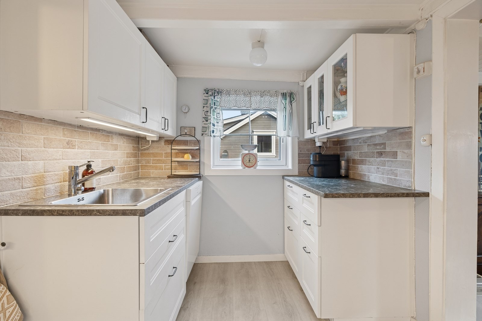 Innredningen har hvite, profilerte fronter og laminat benkeplate. Galleribilde