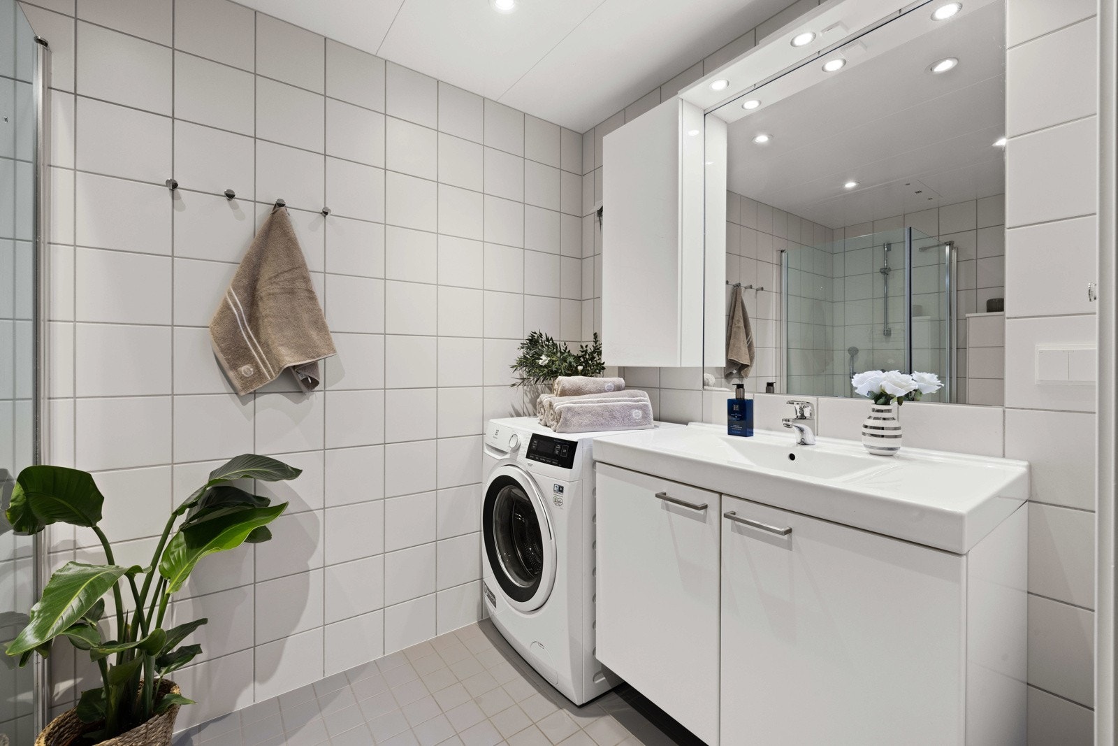 Rommet er utstyrt med innredning med nedfelt servant, veggmontert toalett og dusjhjørne med glassvegger, samt opplegg for vaskemaskin. Galleribilde