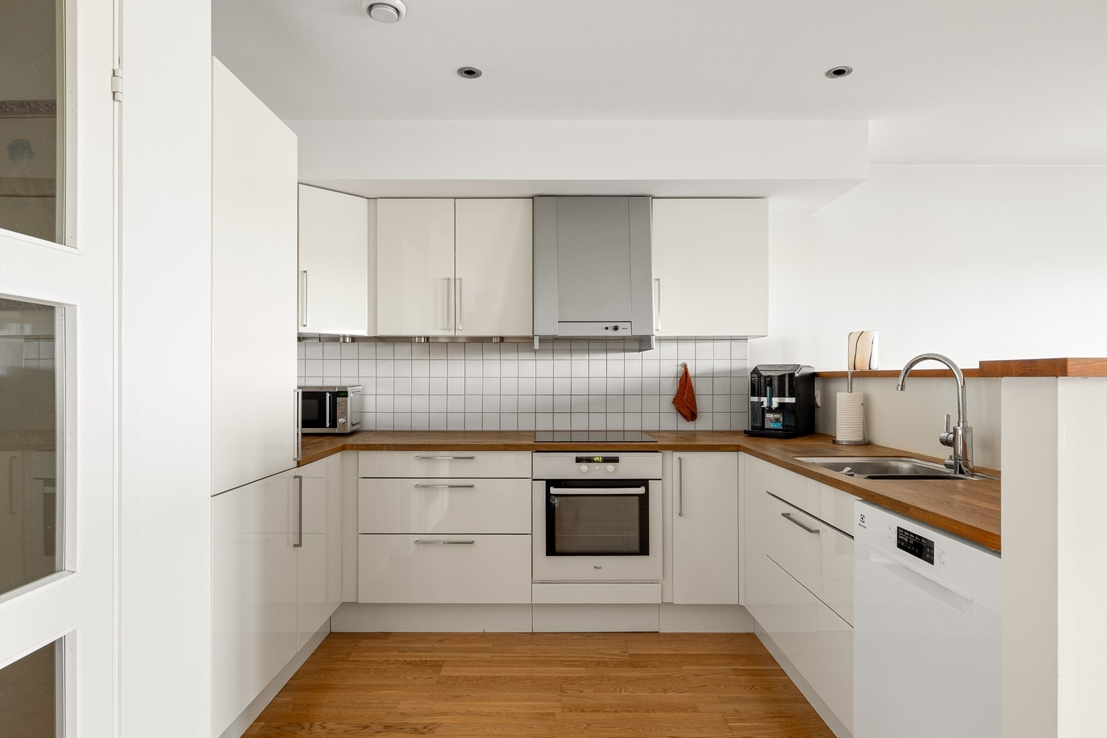 Hvitt kjøkken med god skap- og benkeplass og integrerte hvitevarer. Galleribilde