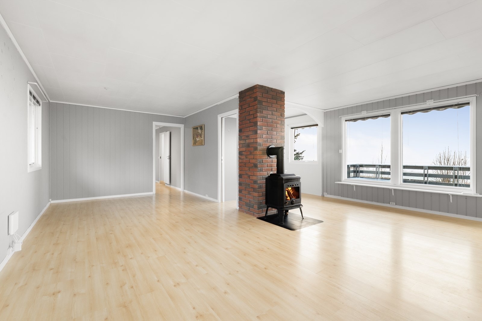 Lys og romslig stue med store vindusflater og kjøkken i åpen løsning. De store vindusflatene slipper inn godt med naturlig lys og gir fin utsikt! Galleribilde