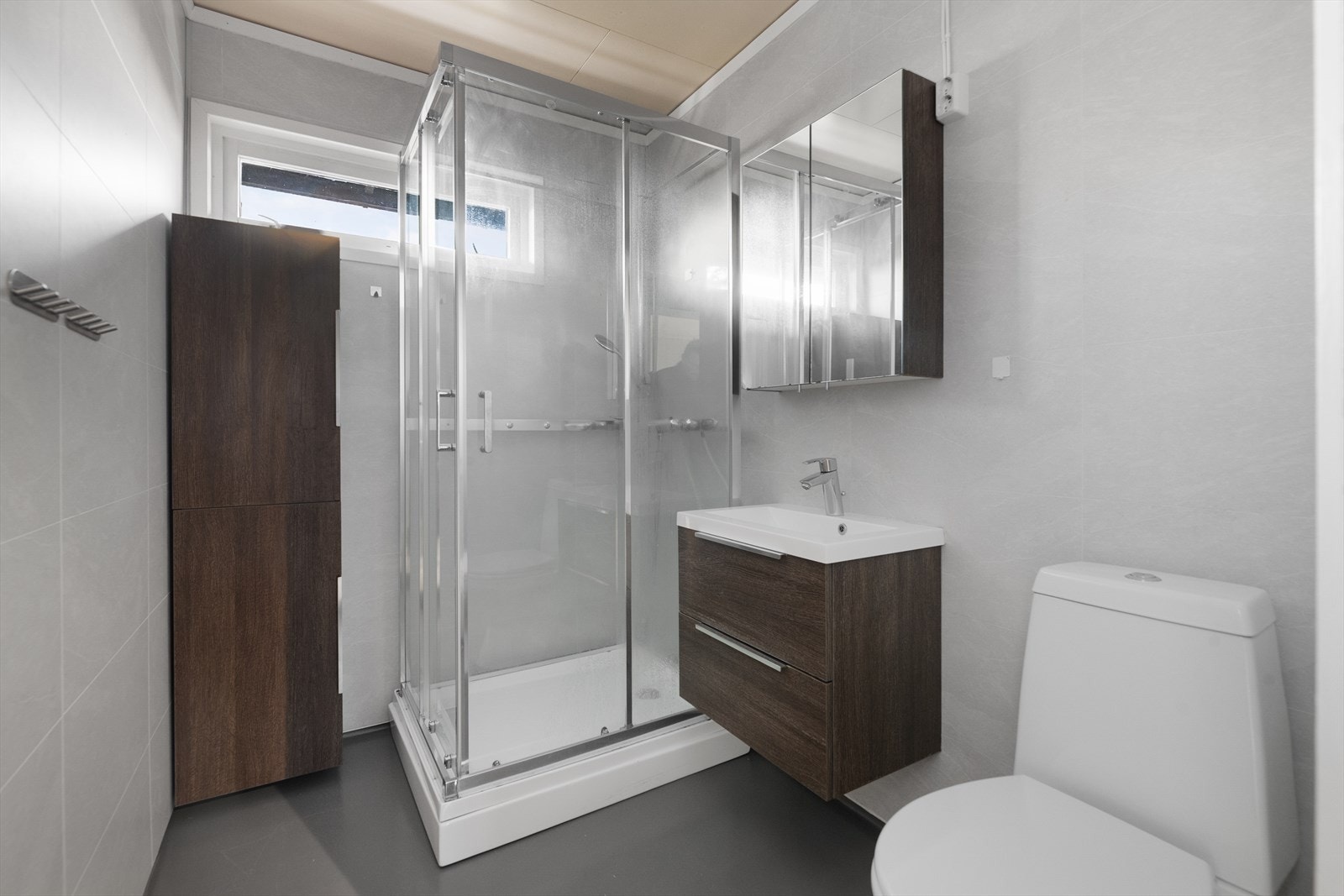 Badet i hovedetasjen er pusset opp i 2017 og har gulvmontert toalett, dusjkabinett og pen servantinnredning. Tilhørende speil- og høyskap. Galleribilde