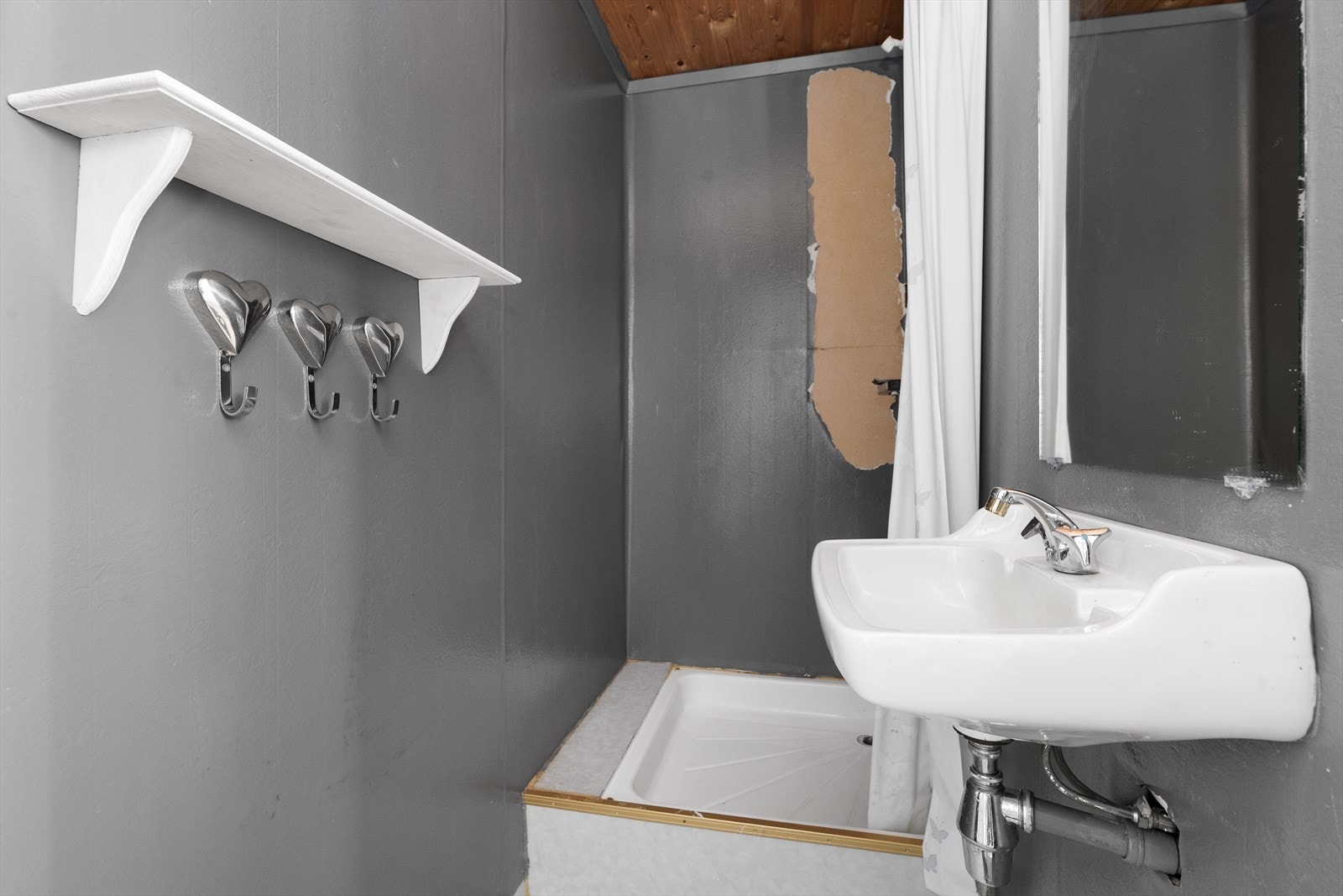 Badet i underetasjen er av eldre standard og har vegghengt servant, samt opplegg til dusj. Badet må oppgraderes for å tåle normalt bruk etter dagens krav. Galleribilde