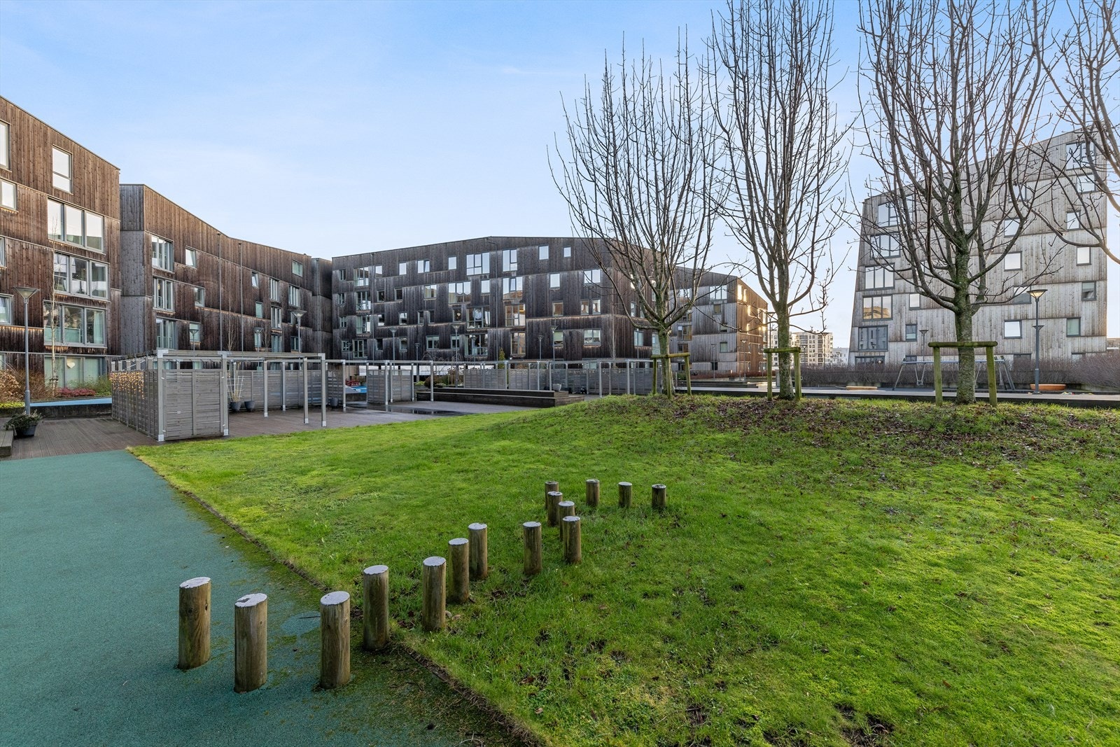 Flotte fellesområde mellom bygningene med bla. grøntområder, lekeplass og sittegrupper Galleribilde