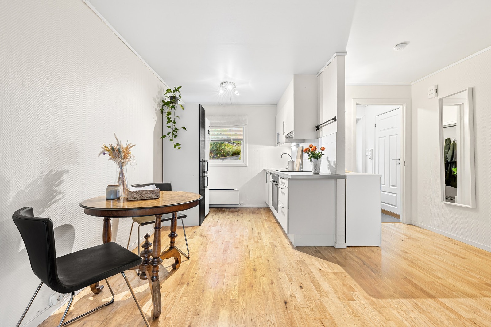 Mellom stue og kjøkken er det plass til et lite spisebord. Galleribilde