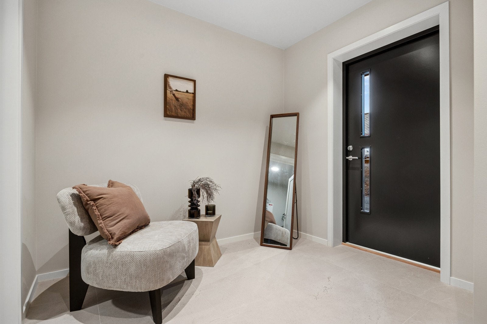 Boligen ønskes velkommen med en romslig, flislagt entré i delikate grå/beige toner. Her er det god plass til garderobeløsning for yttertøy og sko. Galleribilde