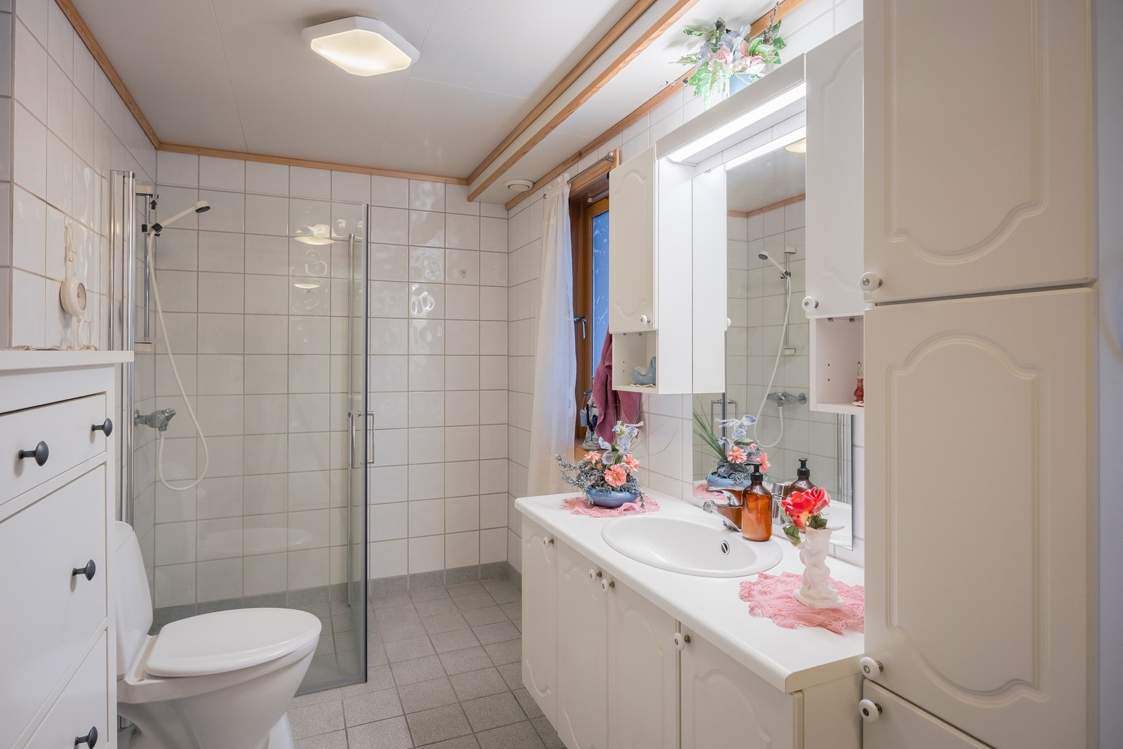 Romslig og flislagt baderom som kombineres med vaskerom. Galleribilde