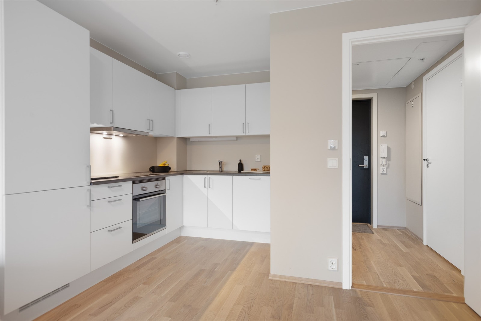 Kjøkkenet har innredning med glatte fronter og benkeplate av laminat Galleribilde