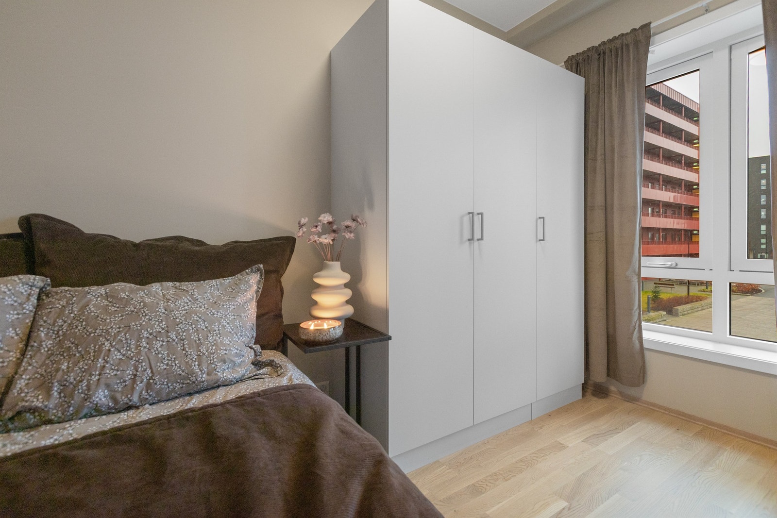 Soverom i lyse farger med parkett på gulv Galleribilde