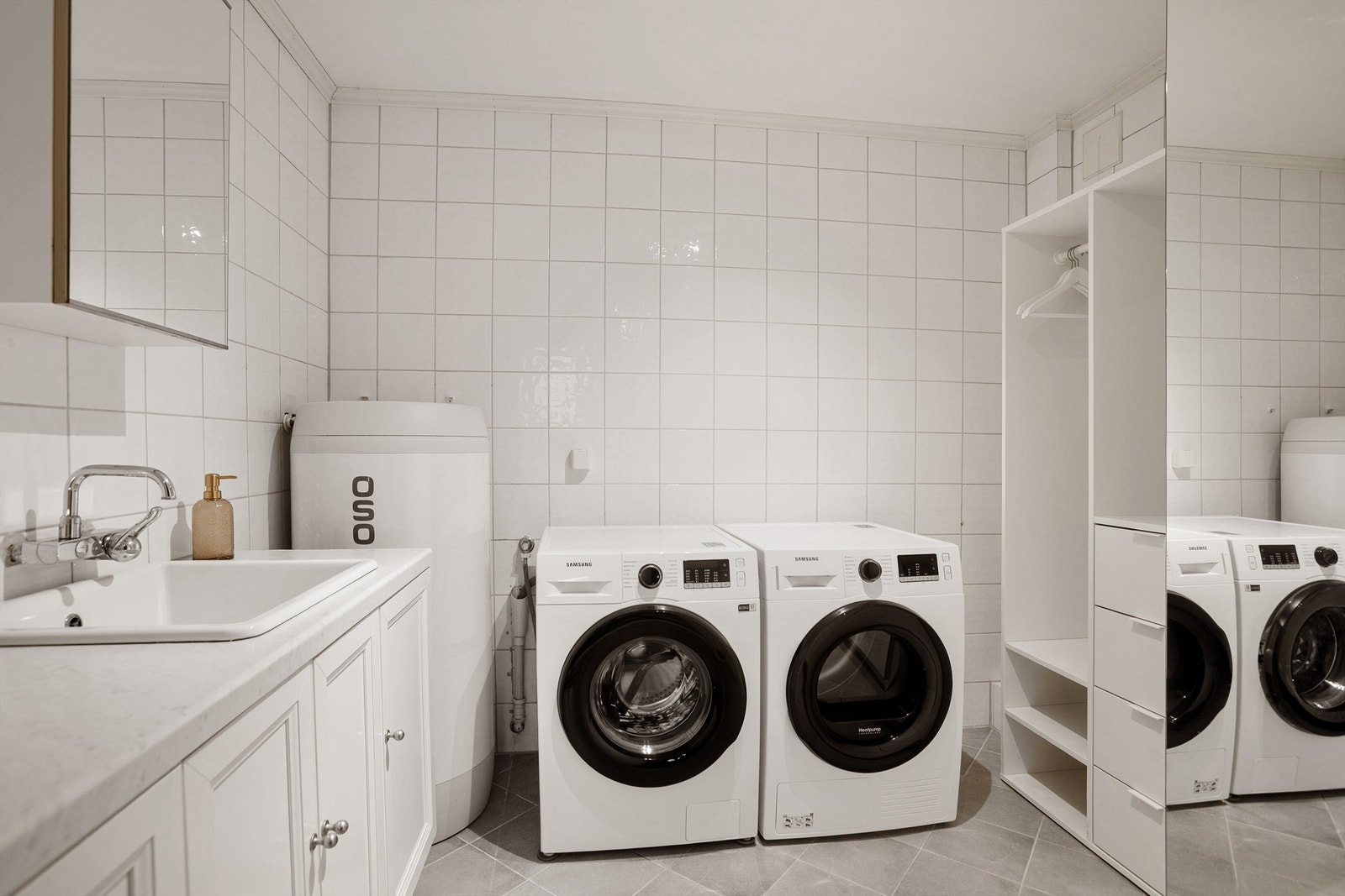 Pent flislagt vaskerom med god plass til vaskemaskin og tørketrommel Galleribilde