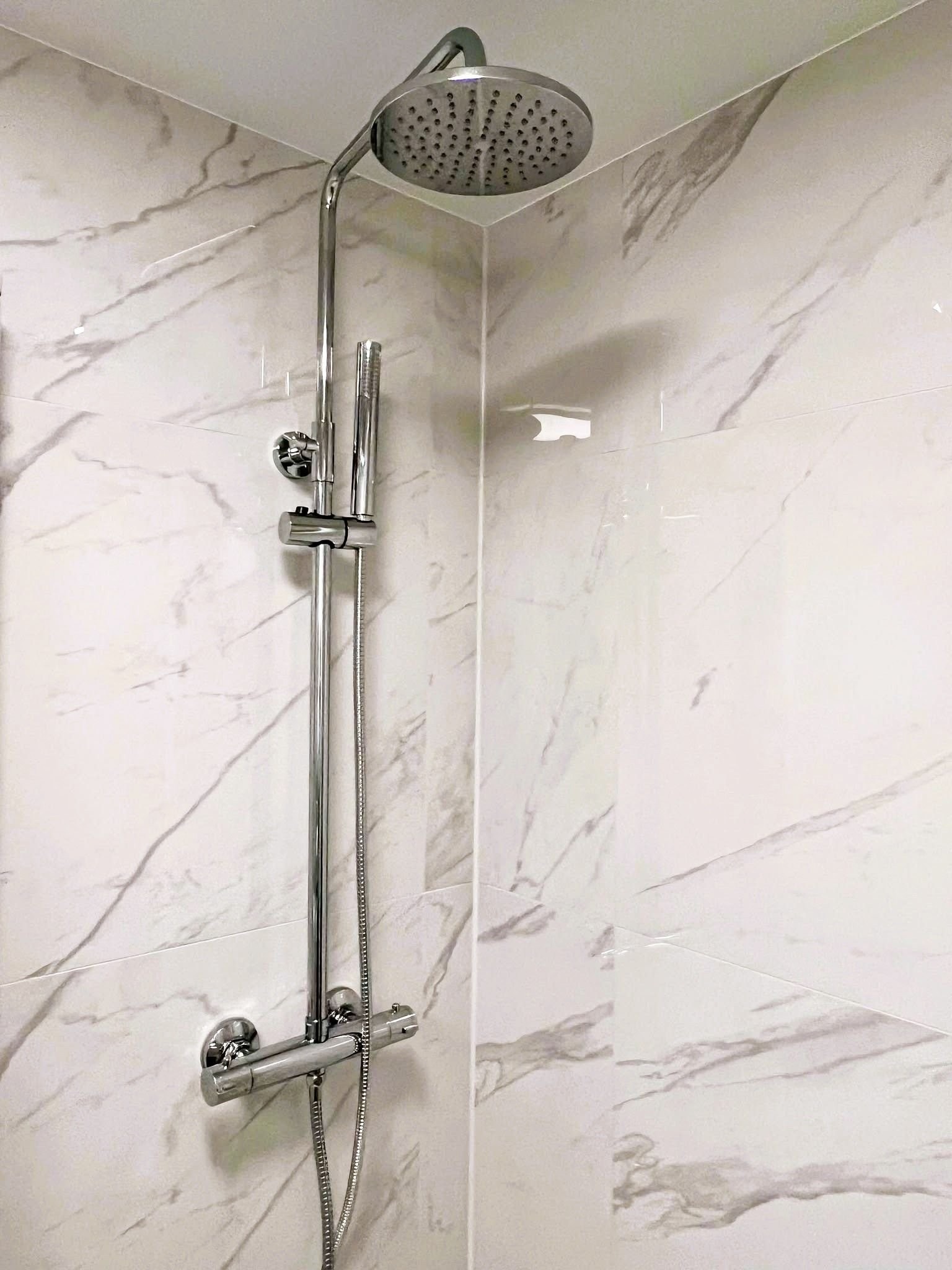 Dusjhjørne med dusjdører. Alle armaturer i leiligheten er nye i lekker krom Galleribilde