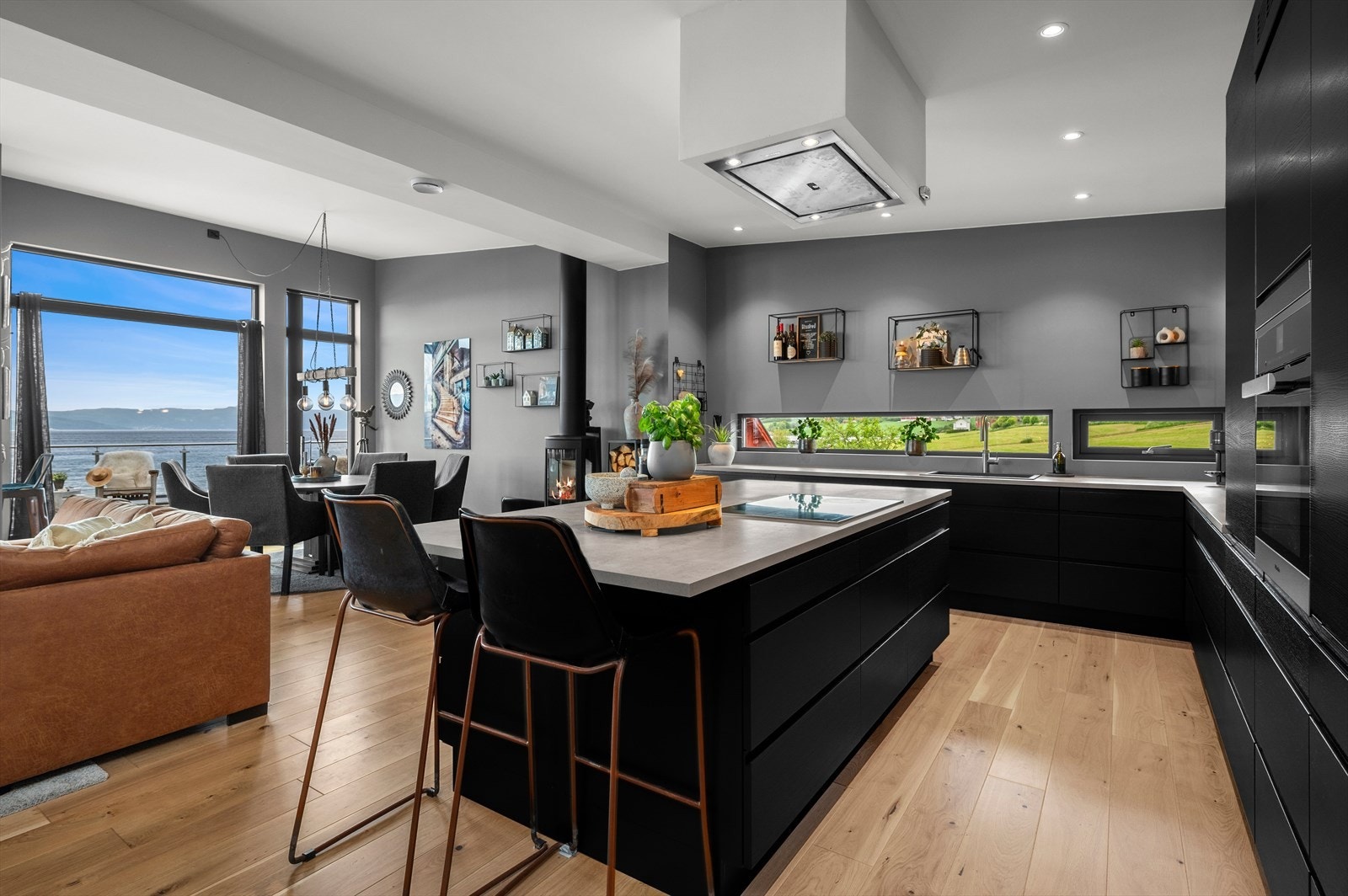 Kjøkkenøyen bidrar til en litt mer naturlig adskilt sone mellom stue og kjøkken, men likevel fremstår åpen og luftig. Galleribilde