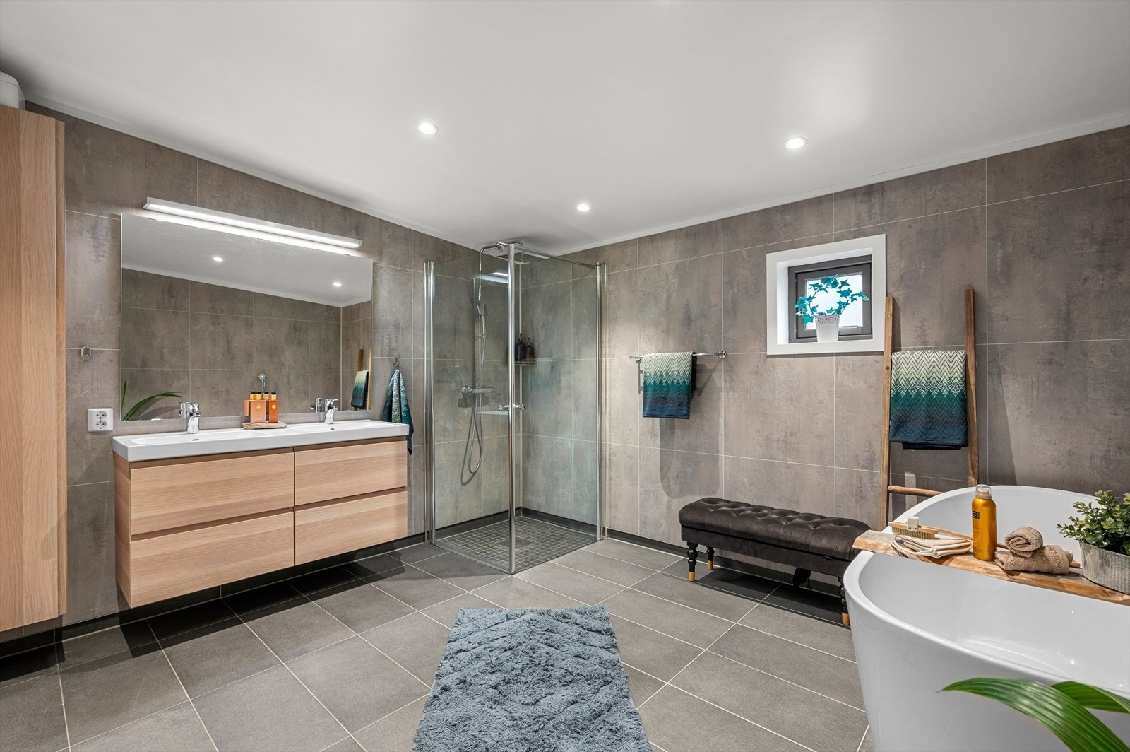 Det største badet i hoveddelen er romslige 9,5 m² og fremstår i ypperlig kvalitet. Her er det flislagt gulv og vegger med downlights i himling. Galleribilde