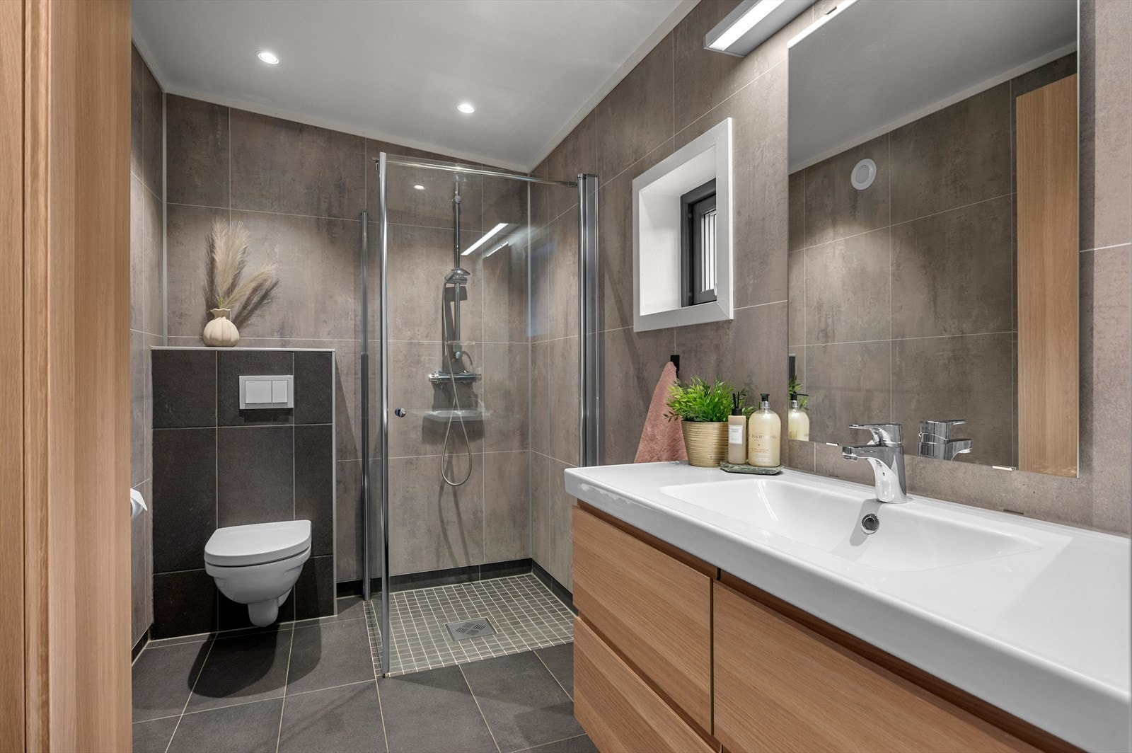 Utleiedelen har flislagt bad med behagelig varme i gulv, vegghengt toalett, dusj og servant i skap. Galleribilde