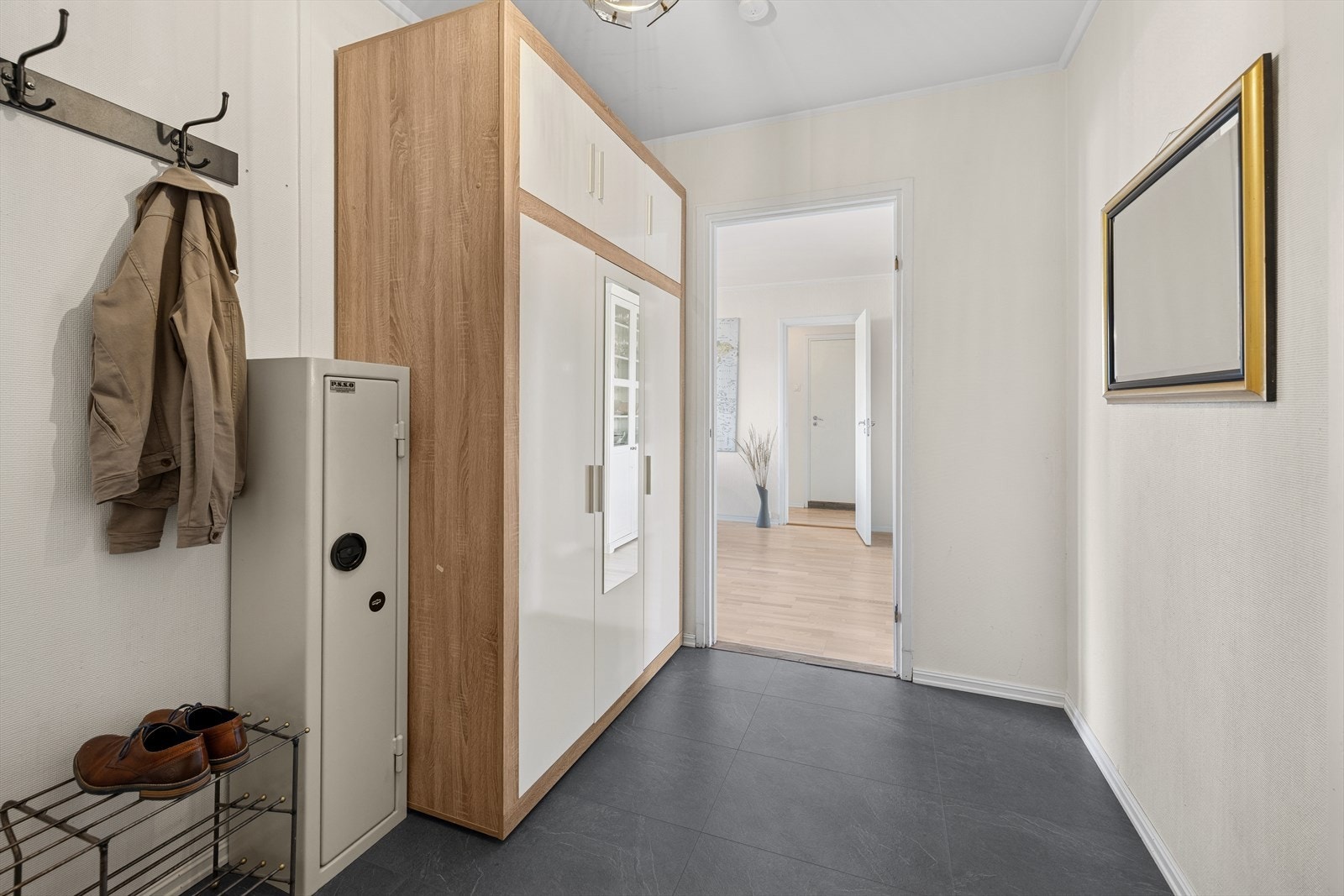 Innenfor døren møtes du av en lys entré med oppbevaringsplass i garderobeskap. Galleribilde