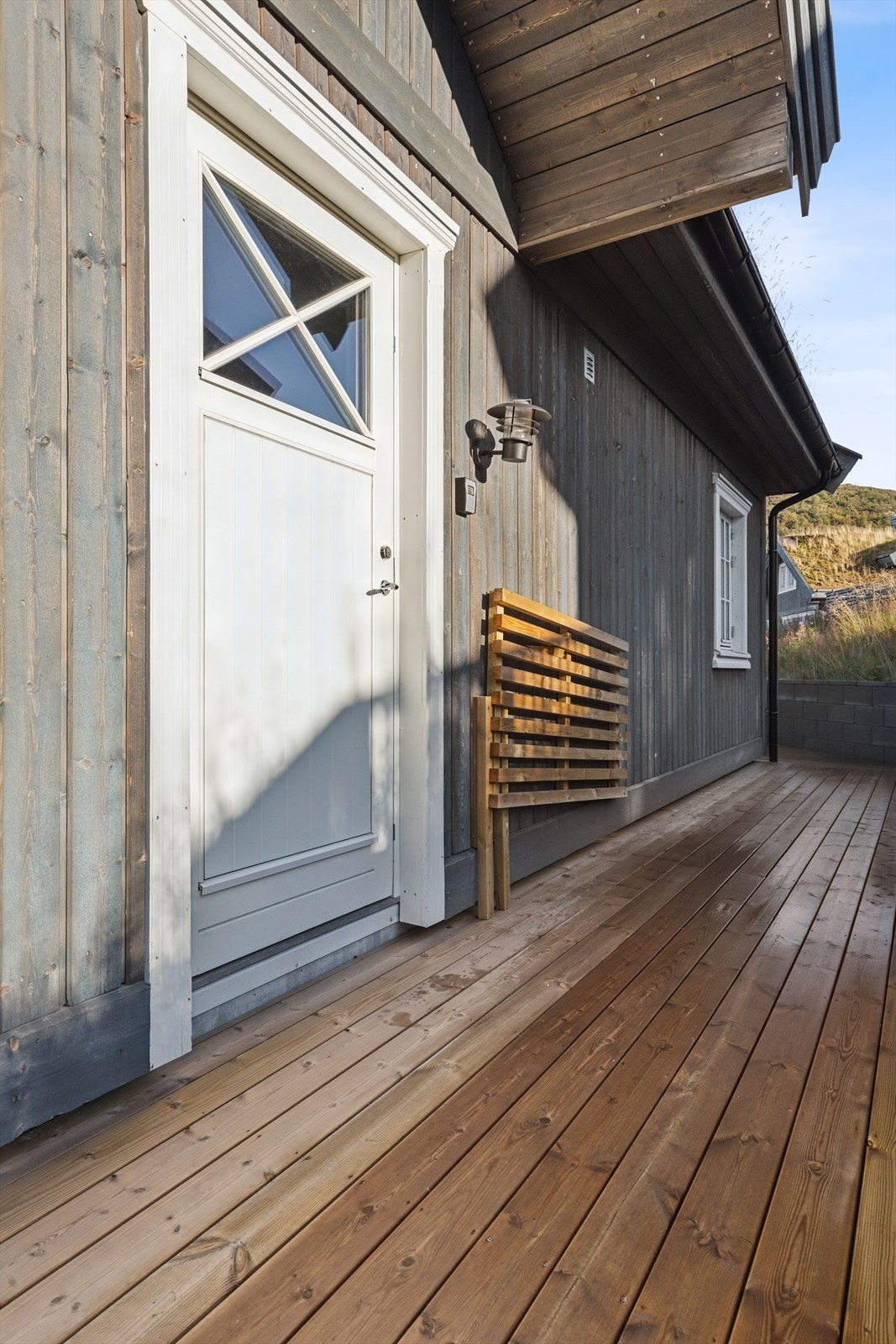 Velkommen til et praktisk og innbydende overbygd inngangsparti med direkte adkomst til hyttas terrasse - perfekt for å kunne nyte solen på ulike tider av dagen. Galleribilde