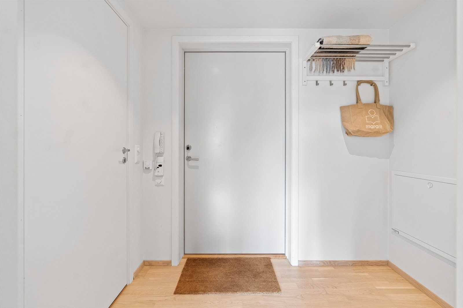 Leiligheten har en lys entré, med plass til å henge fra seg yttertøy og sette fra seg sko. Galleribilde