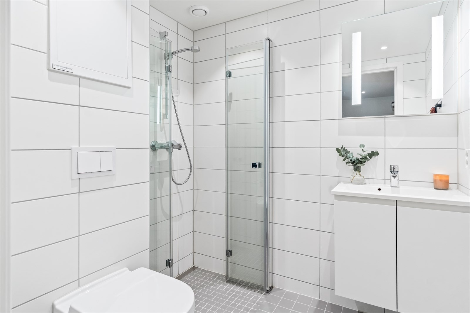 Under servanten er det benkeskap med glatte fronter, og over servanten er det montert speil med belysning. Galleribilde