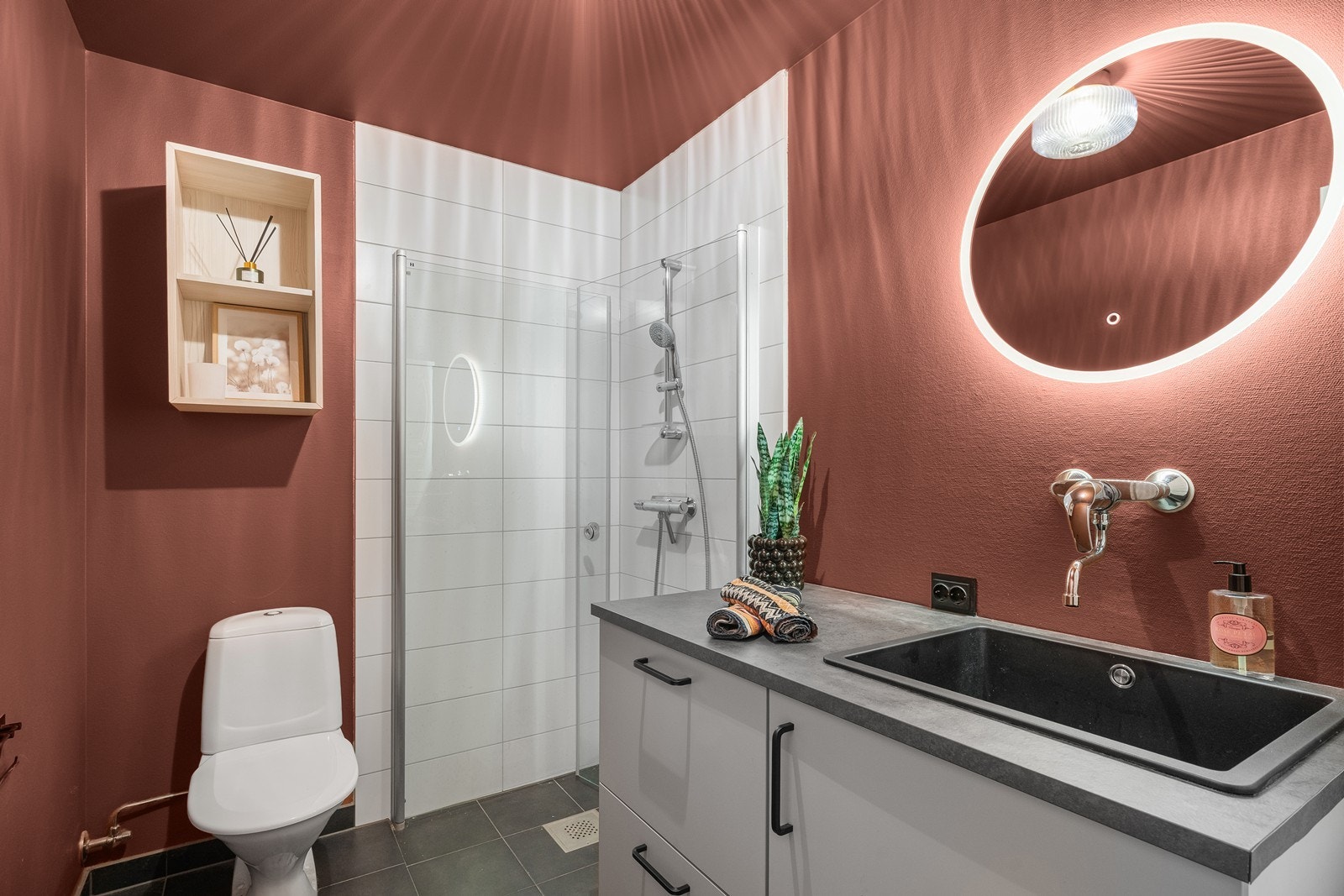 Moderne baderom med dusj, toalett og praktisk innredning med plass til vaskemaskin og tørketrommel. Galleribilde