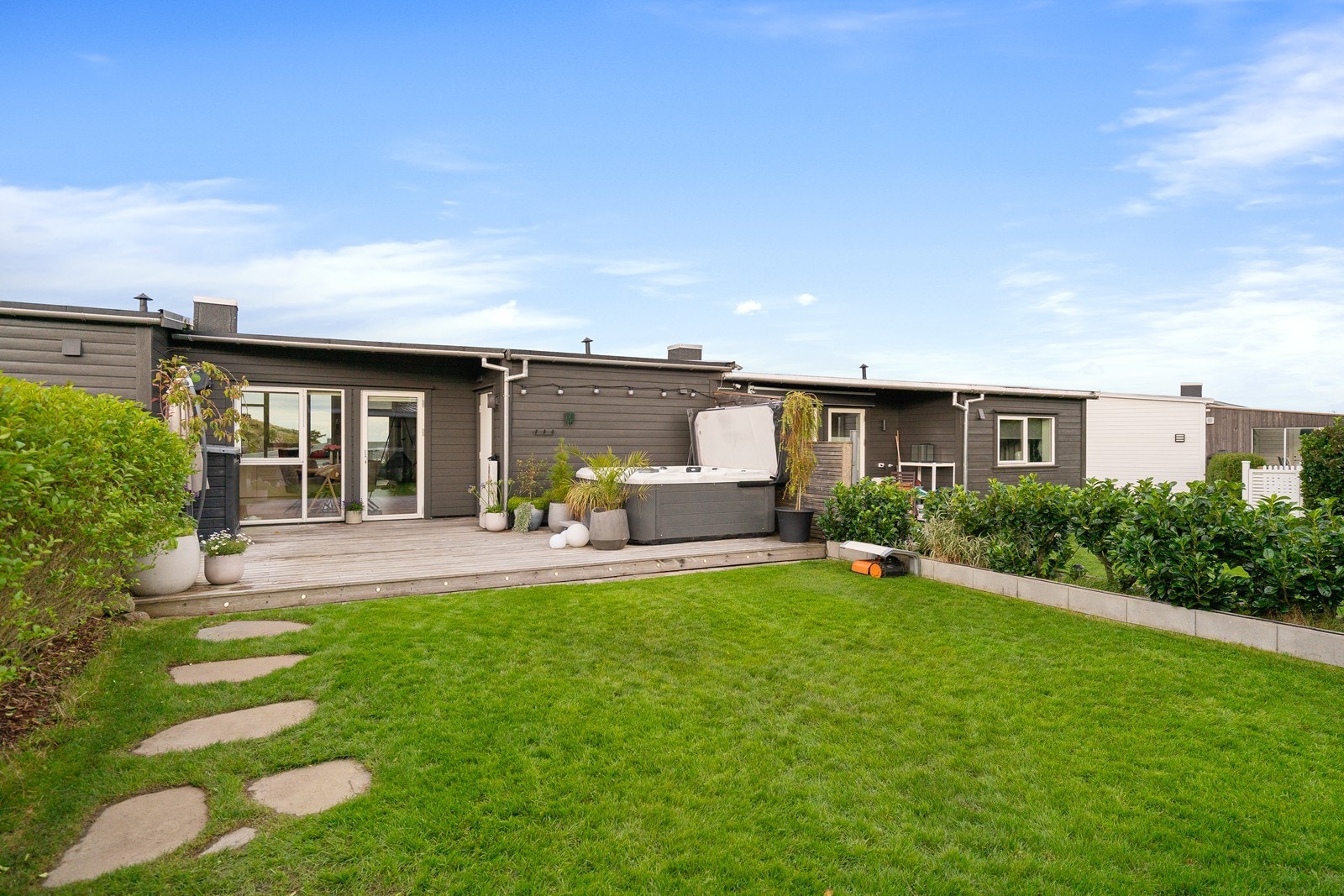 En stor og innbydende terrasse hvor jacuzzi og generøs plass gir rom for både velvære og hyggelige samlinger. Et naturlig samlingspunkt med enkel tilgang fra kjøkken og stue. Galleribilde