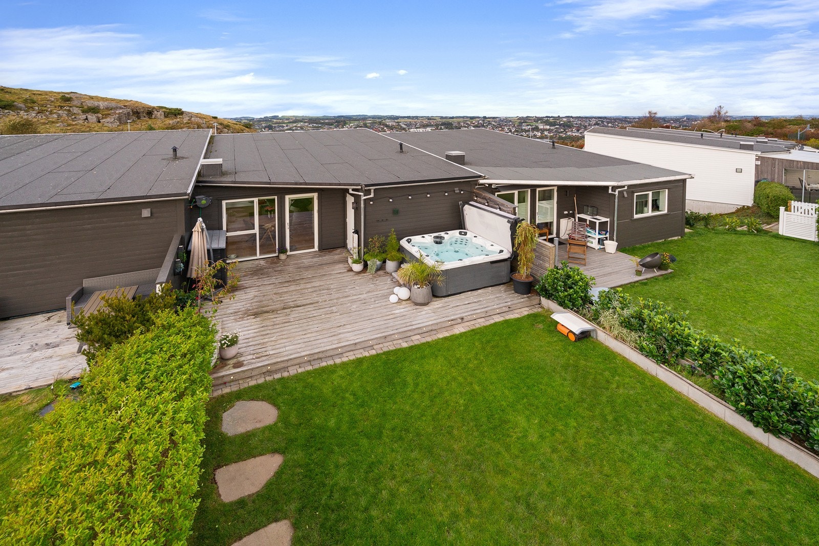 En romslig uteplass med terrasse og hage som fungerer som en forlengelse av oppholdsrommene. Jacuzzi medfølger i handelen. Galleribilde