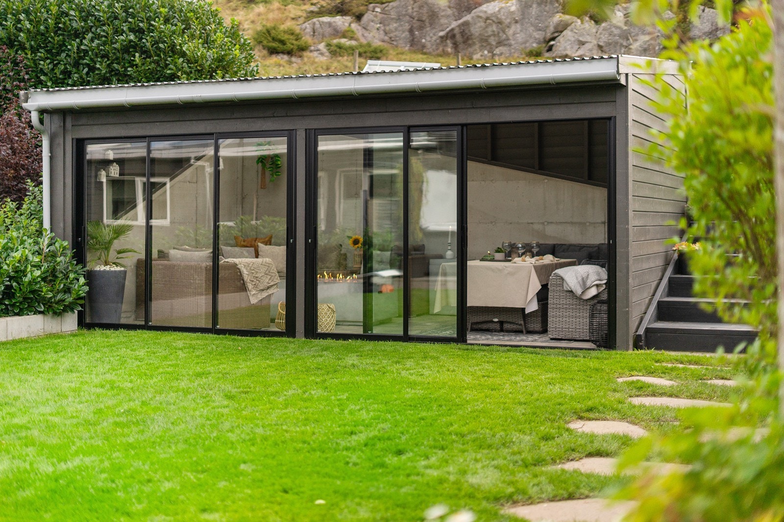 Sjarmerende hagestue (ikke byggemeldt og godkjent) med store skyvefelt i glass, rustikke materialer og god plass til møblering. Galleribilde