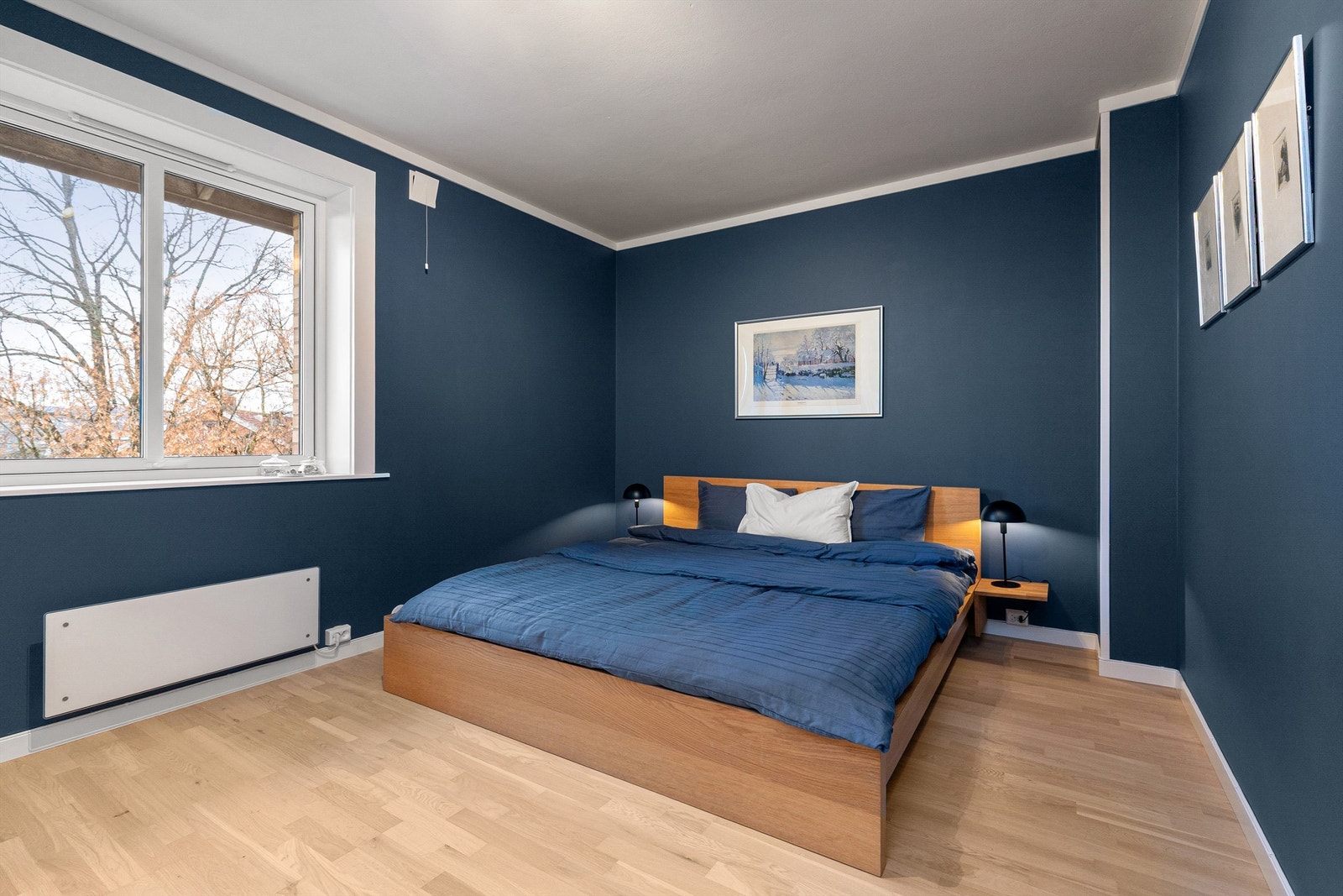 Romslig hovedsoverom med god plass til dobbeltseng og nattbord på hver side av sengen Galleribilde