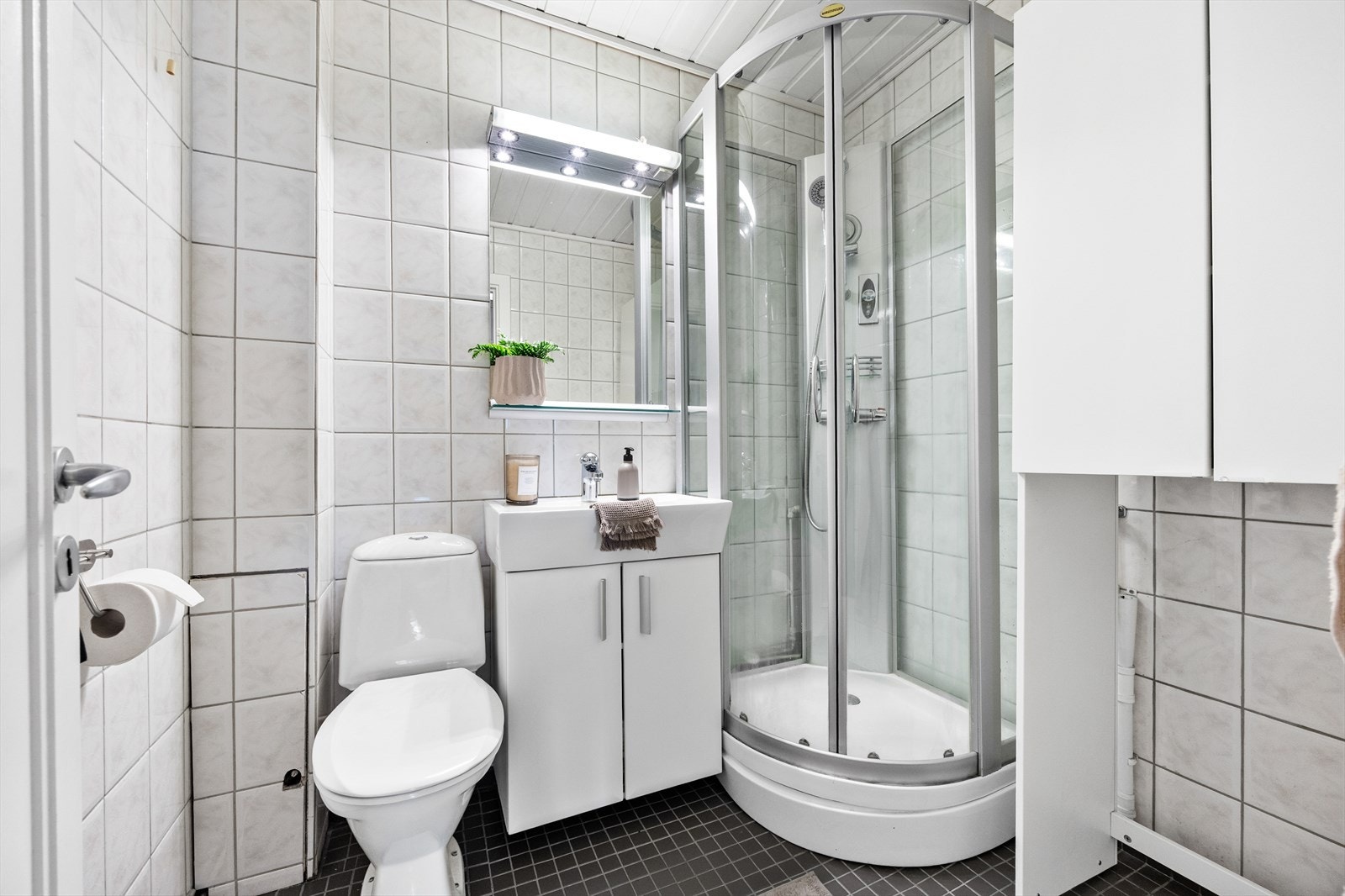 Et funksjonelt bad med servantinnredning og speilskap. Galleribilde