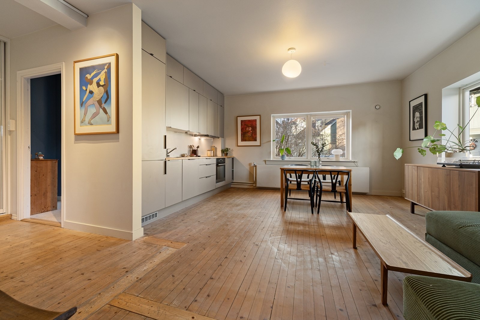 De originale tregulvene gir hjemmet en særegen sjarm, mens de glatte overflatene og de lyse, innbydende fargene forsterker følelsen av romslighet og trivsel. Galleribilde