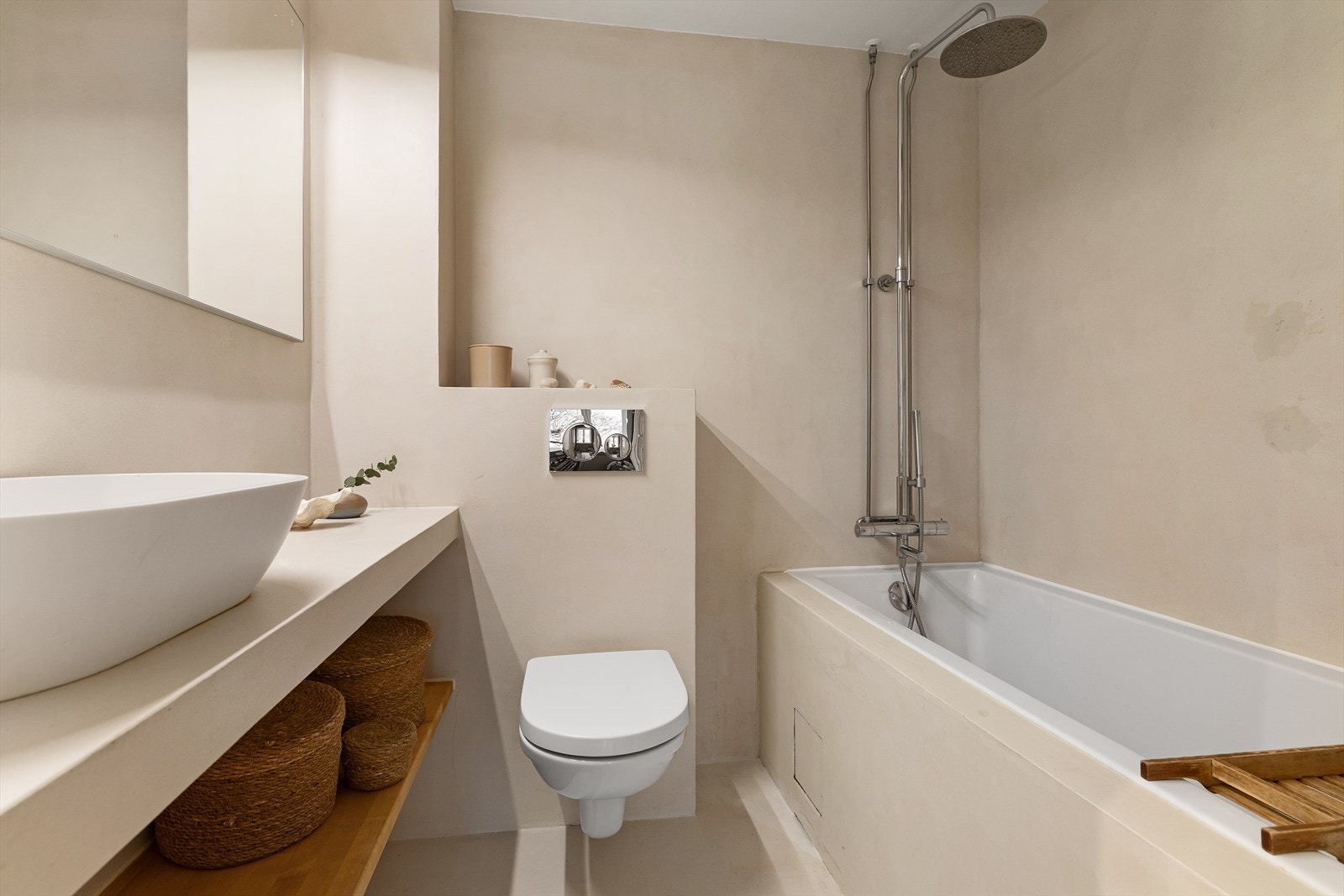 Badet er utstyrt med innredning som inkluderer en nedfelt servant med underskap for oppbevaring, et toalett og badekar. Galleribilde