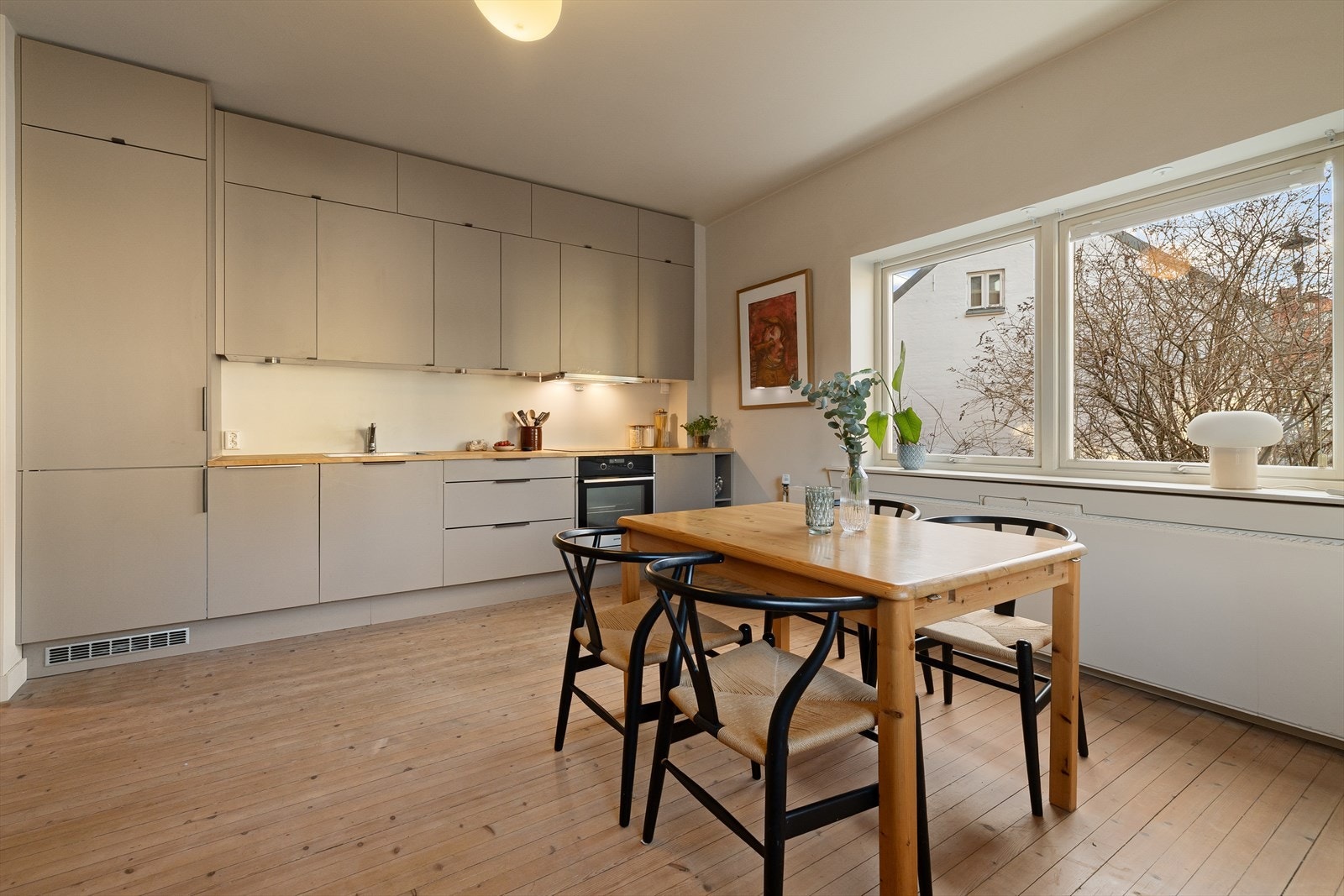 Kjøkkenet er fra 2021 og har en stilren innredningen med glatte fronter som gir et moderne uttrykk, og benkeplaten i heltre. Galleribilde