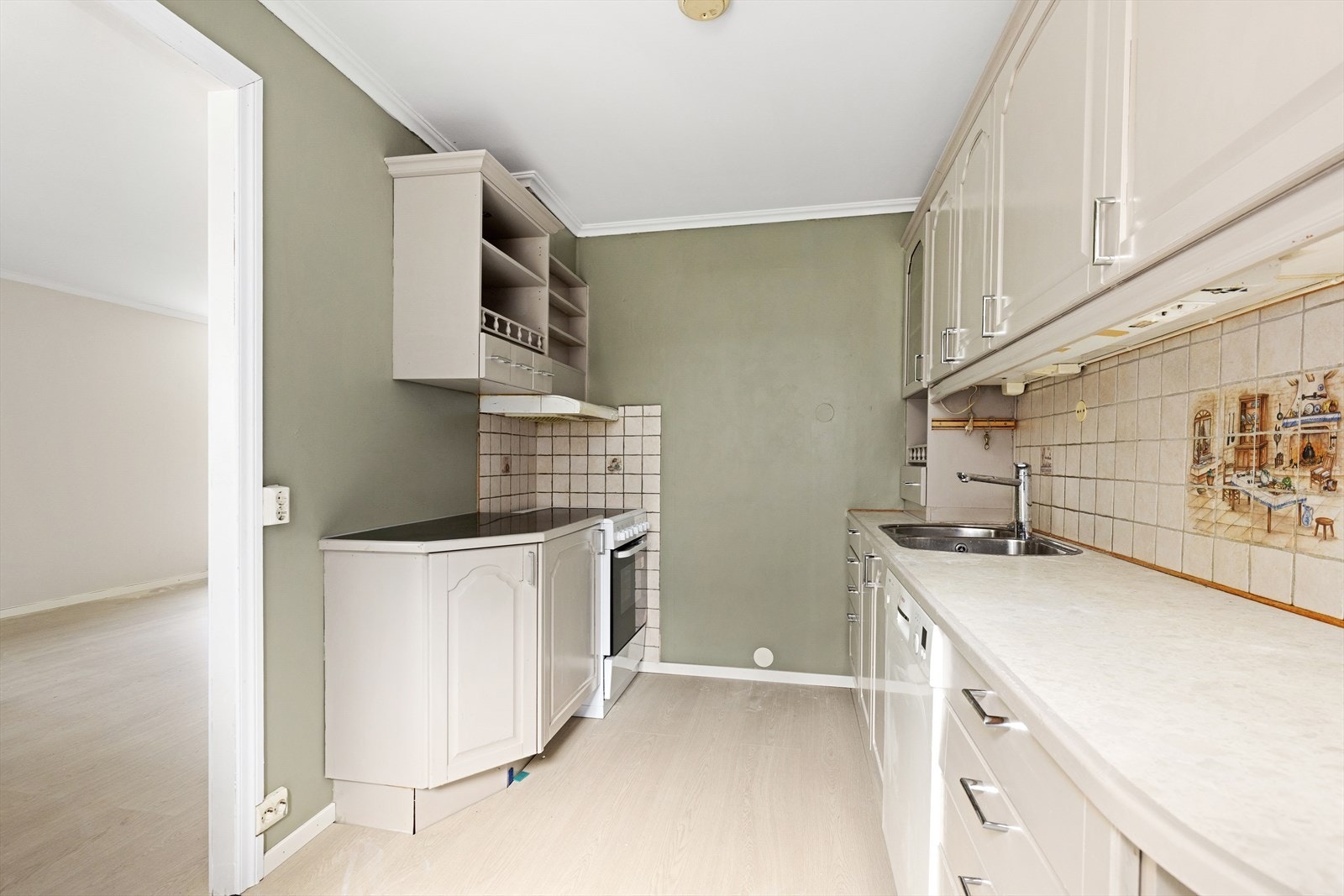 Kjøkkenet har en velholdt, malt furu innredning med profilerte fronter, laminat benkeplate og flis over kjøkkenbenk. Det er ventilator med avtrekk via mekanisk avtrekksanlegg og avsatt plass til komfyr, oppvaskmaskin og kjøleskap. Hvitevarer medfølger. Galleribilde